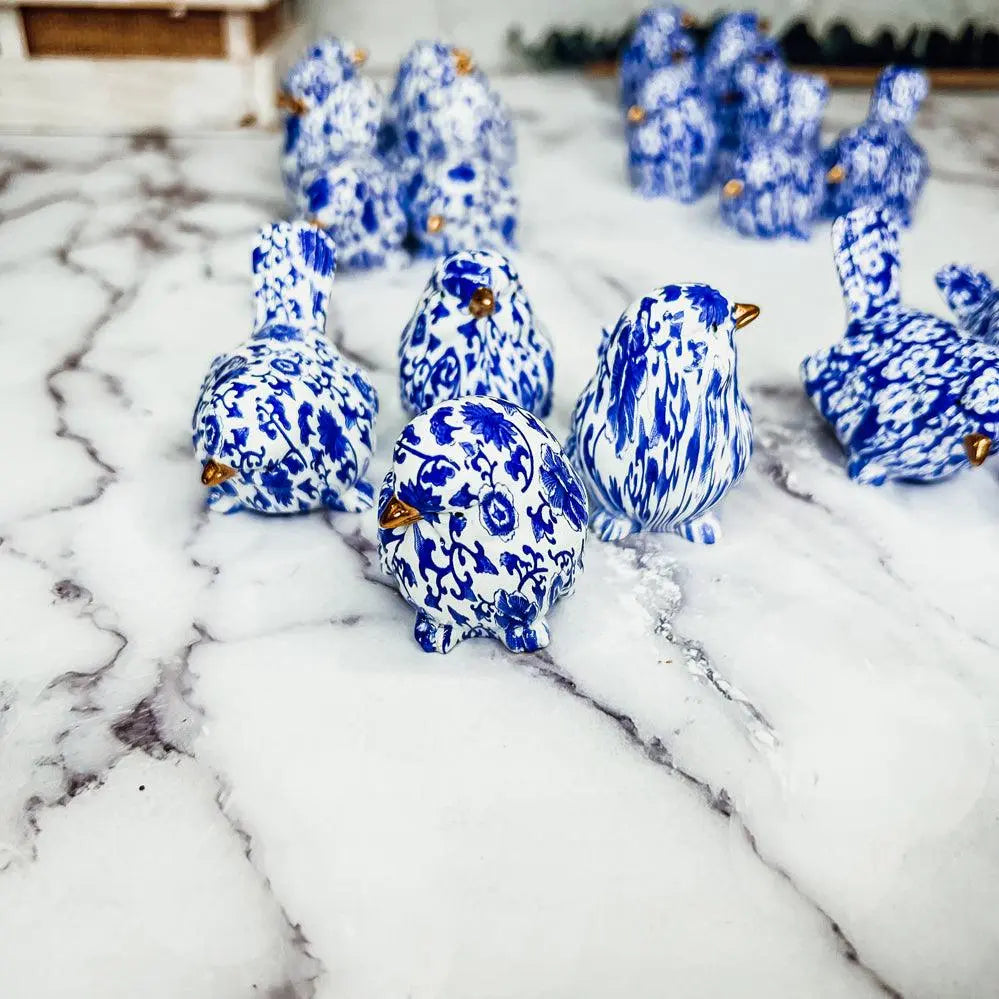 Blue and white ceramic ducks on a marble surface