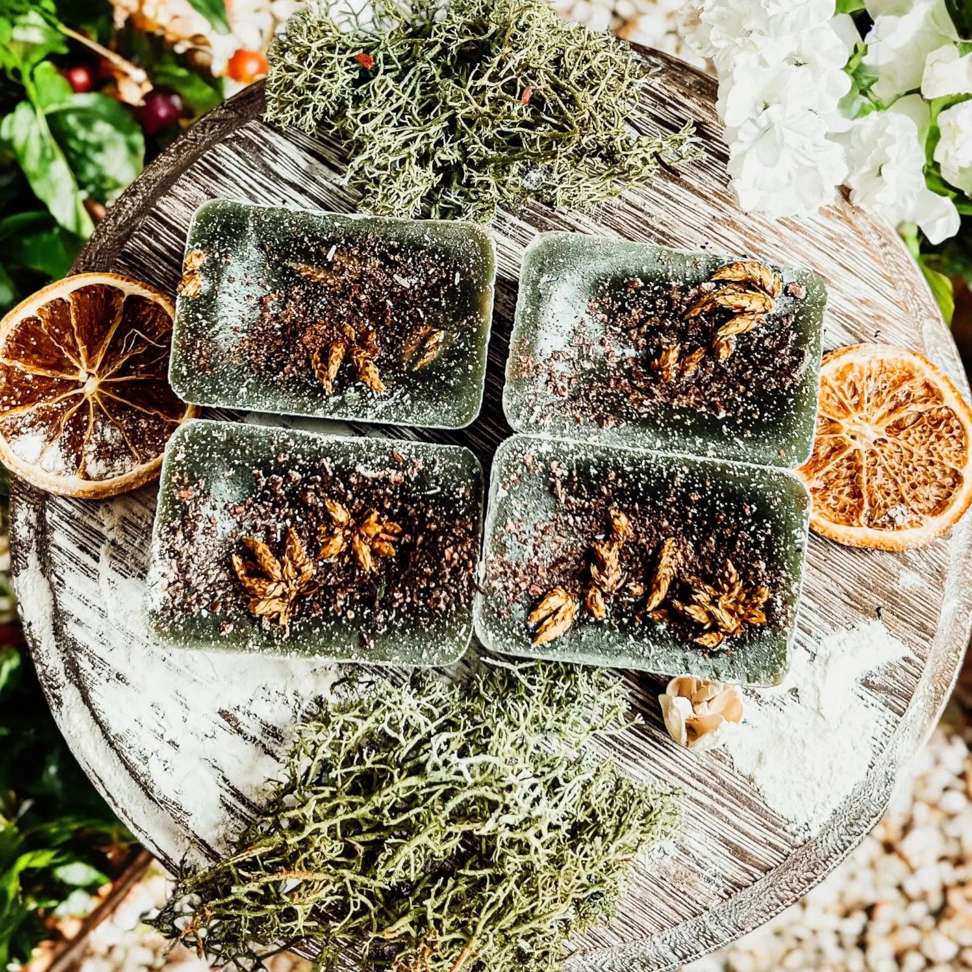 Four green soap bars with natural ingredients on a wooden surface with decorative elements.