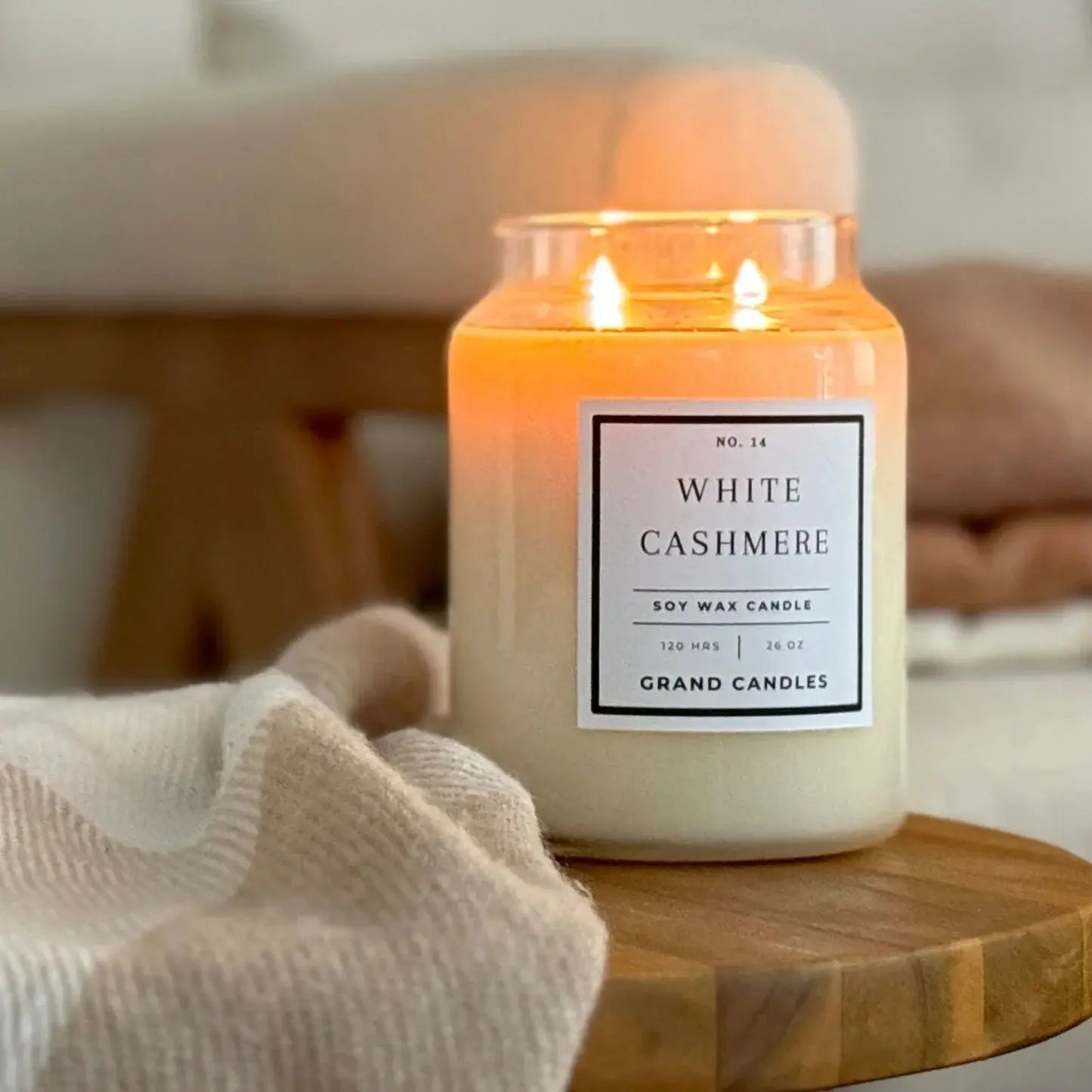 White Cashmere soy wax candle lit on wooden tray, cozy farmhouse decor with soft blanket
