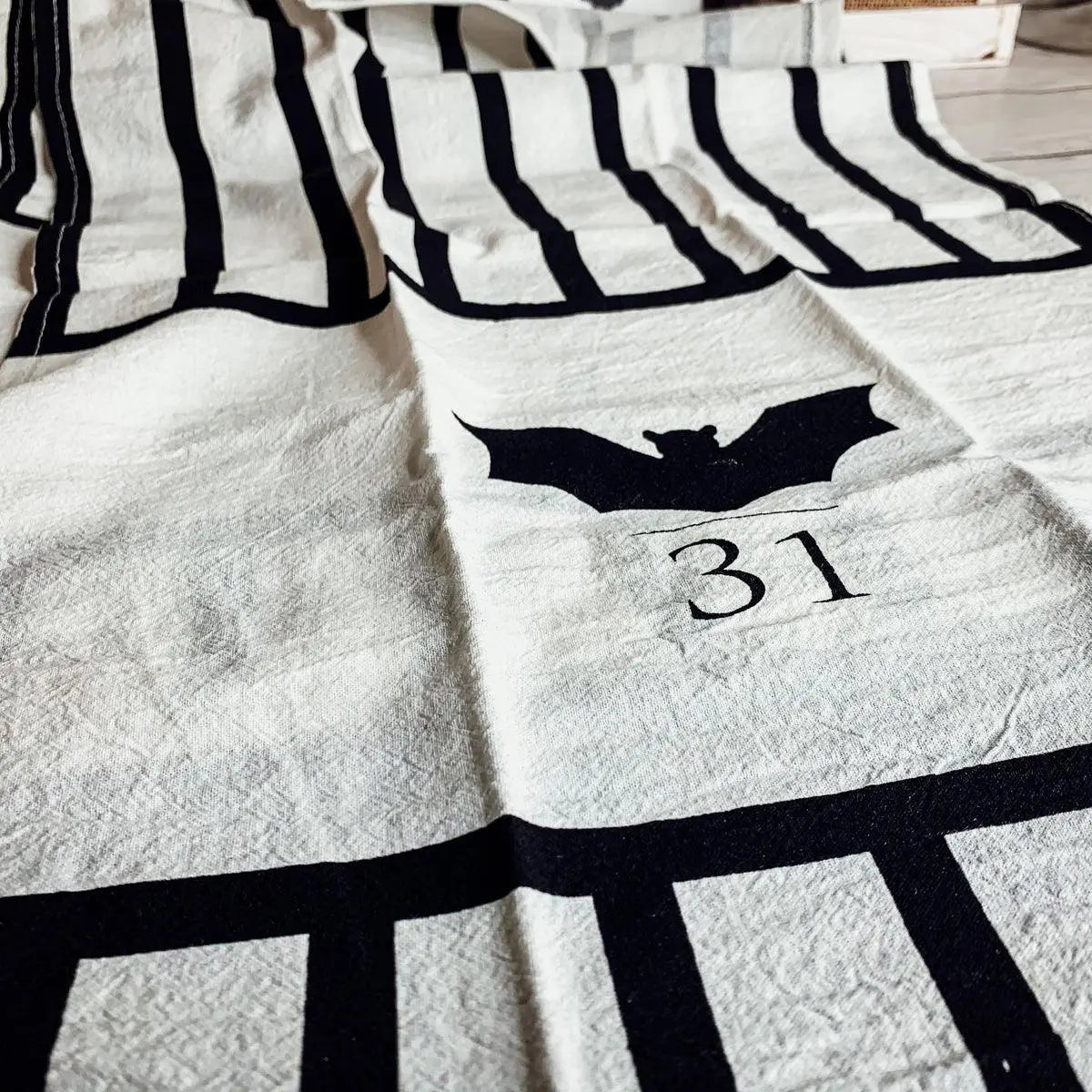Halloween-themed tablecloth with bat and number 31 design on a white surface.