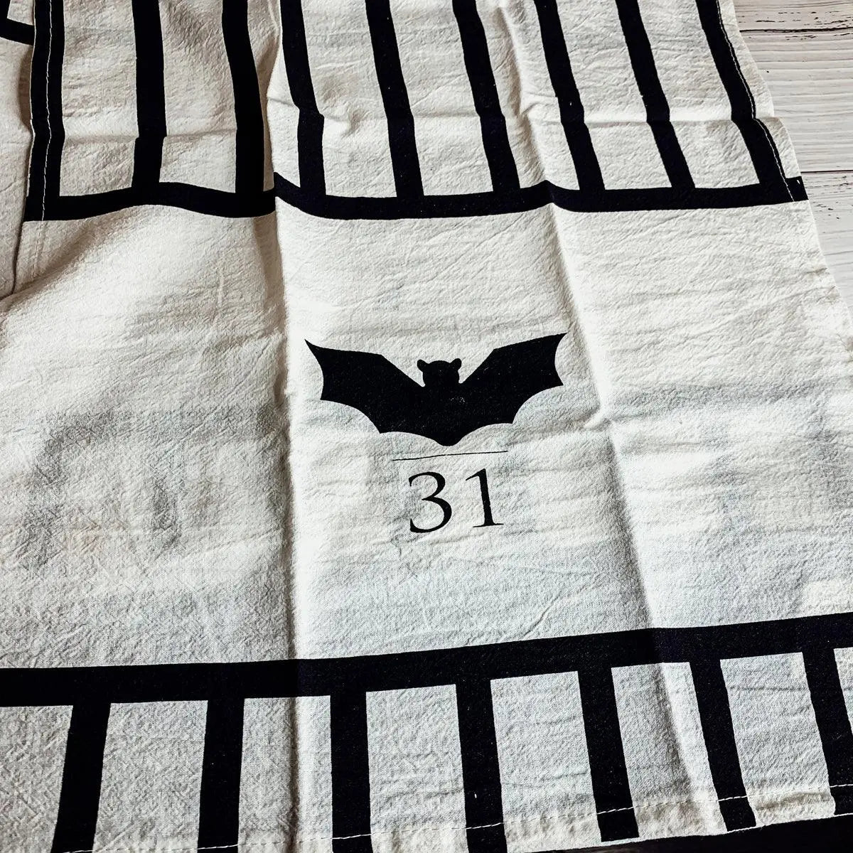 Black bat and number 31 design on a white towel with black stripes.