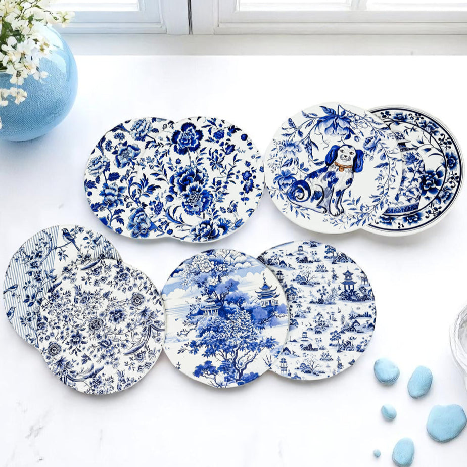 Set of blue and white decorative coasters on a light surface with a vase and flowers in the background.