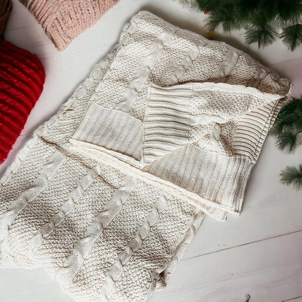 Cozy cream cable knit blanket with farmhouse charm, perfect for warm, peaceful living spaces