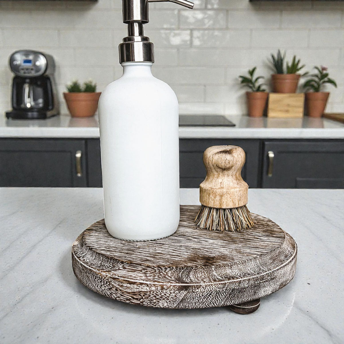 White soap dispenser with wooden brush on a wooden stand in a kitchen setting