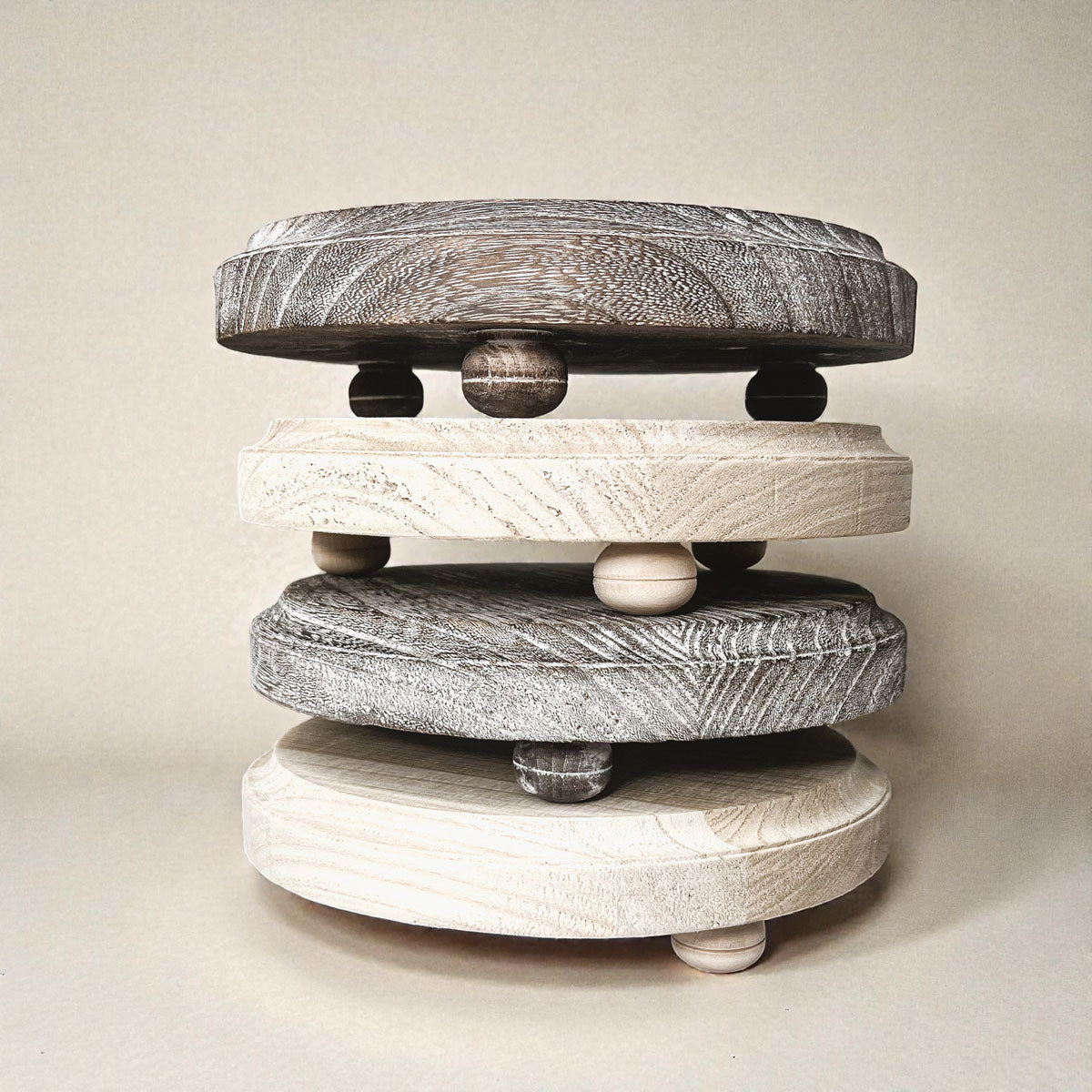 Stack of four round stone weights on a neutral background