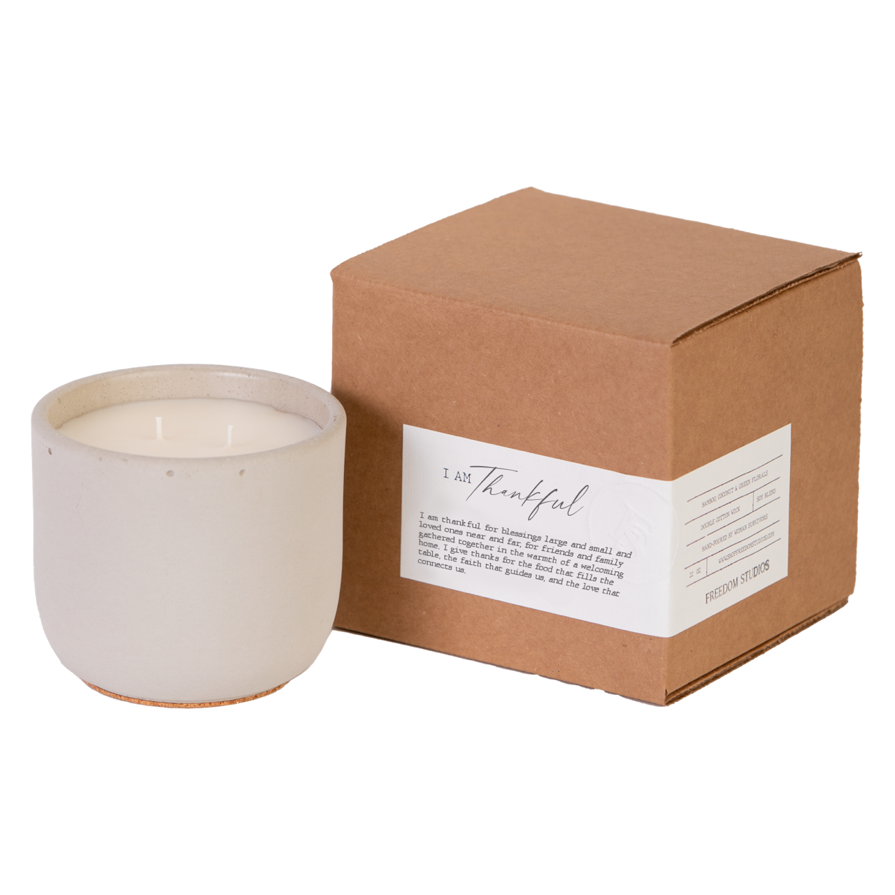 White candle in a ceramic holder next to a brown cardboard box with a label on a white background