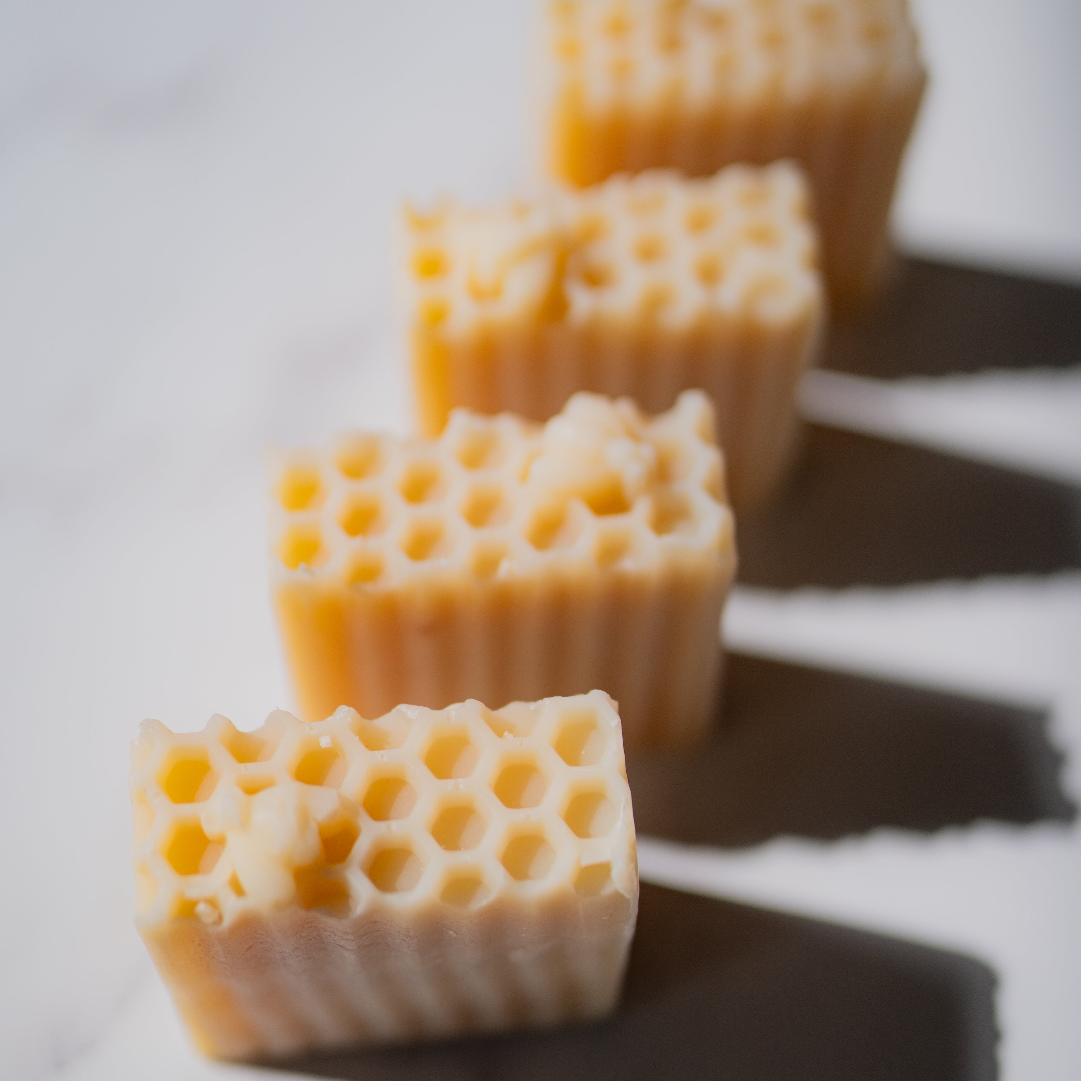 Close-up of honeycomb-shaped candles on a white background