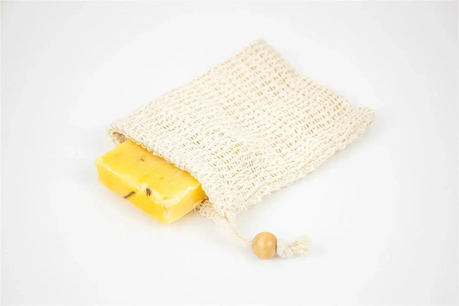 Yellow handmade soap bar in natural mesh soap saver bag with wooden bead drawstring, cozy bath essential