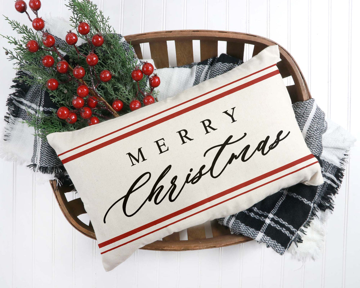 Decorative pillow with 'Merry Christmas' text on a wooden chair with holiday decorations.