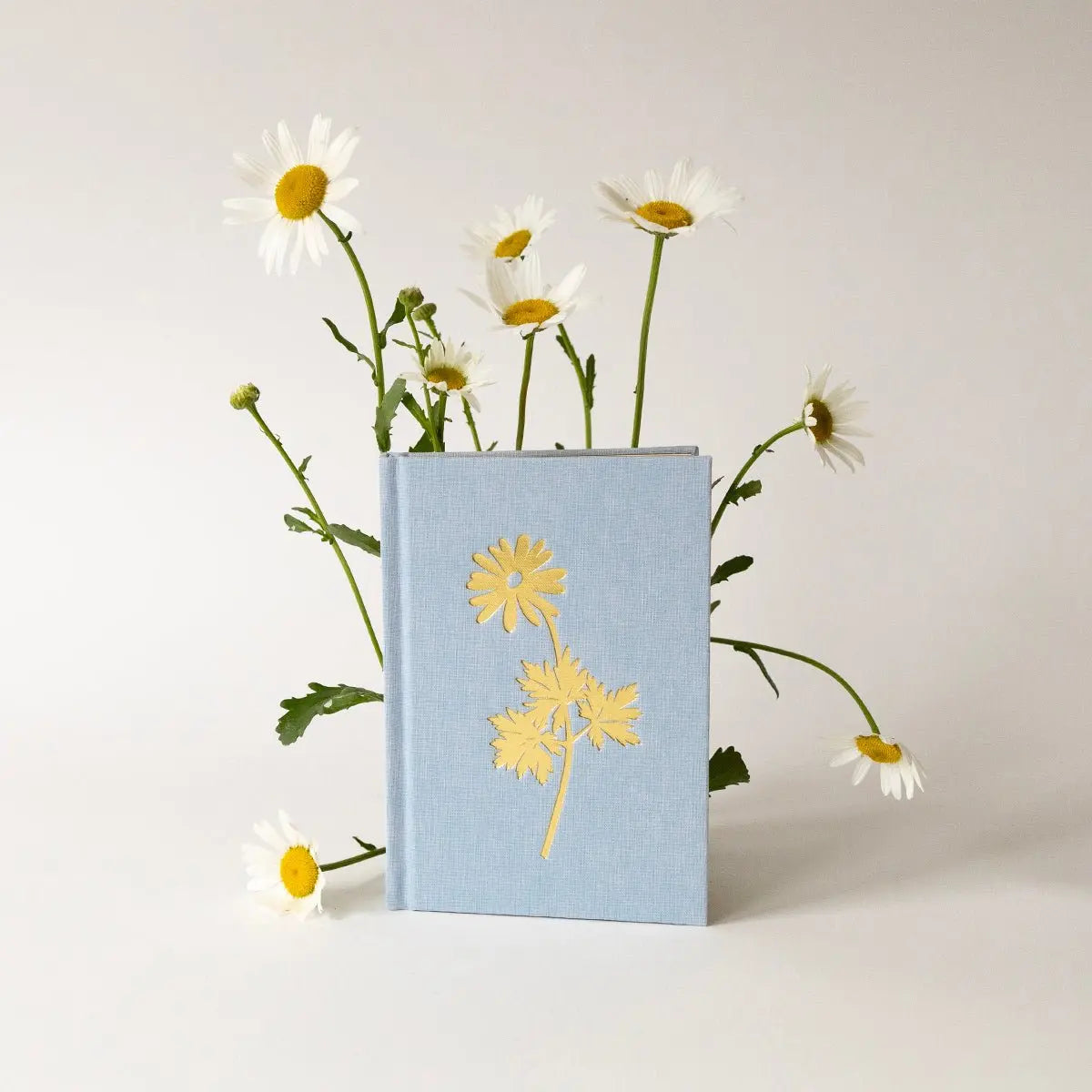 Light blue notebook with yellow floral design on a white background