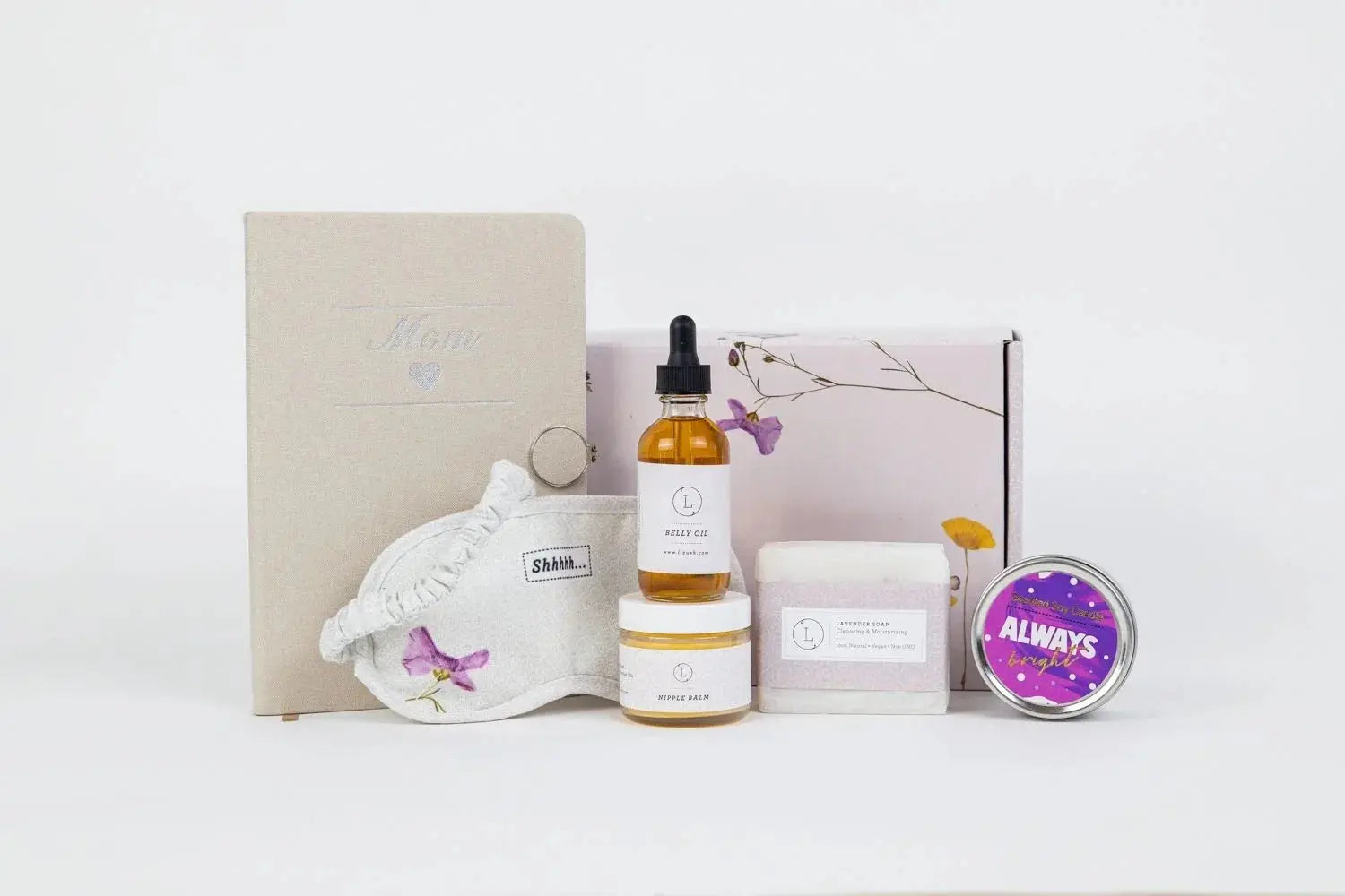 Cozy self-care gift set with lavender soap, belly oil, nipple balm, sleep mask, candle, and mom journal