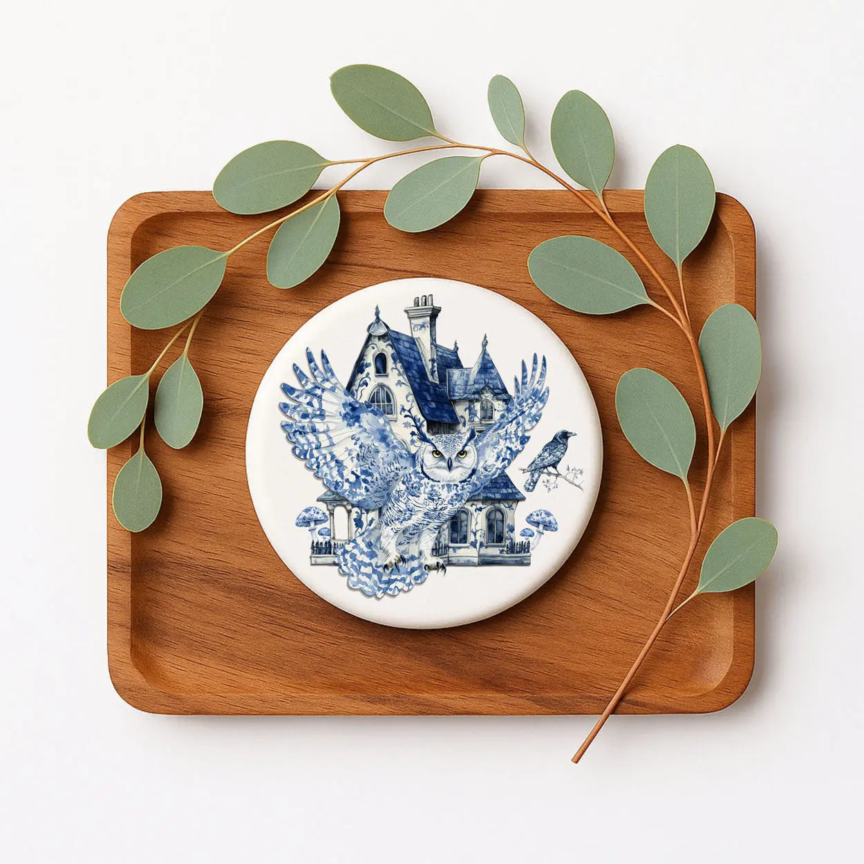 Decorative plate with blue and white design on a wooden tray with leaves