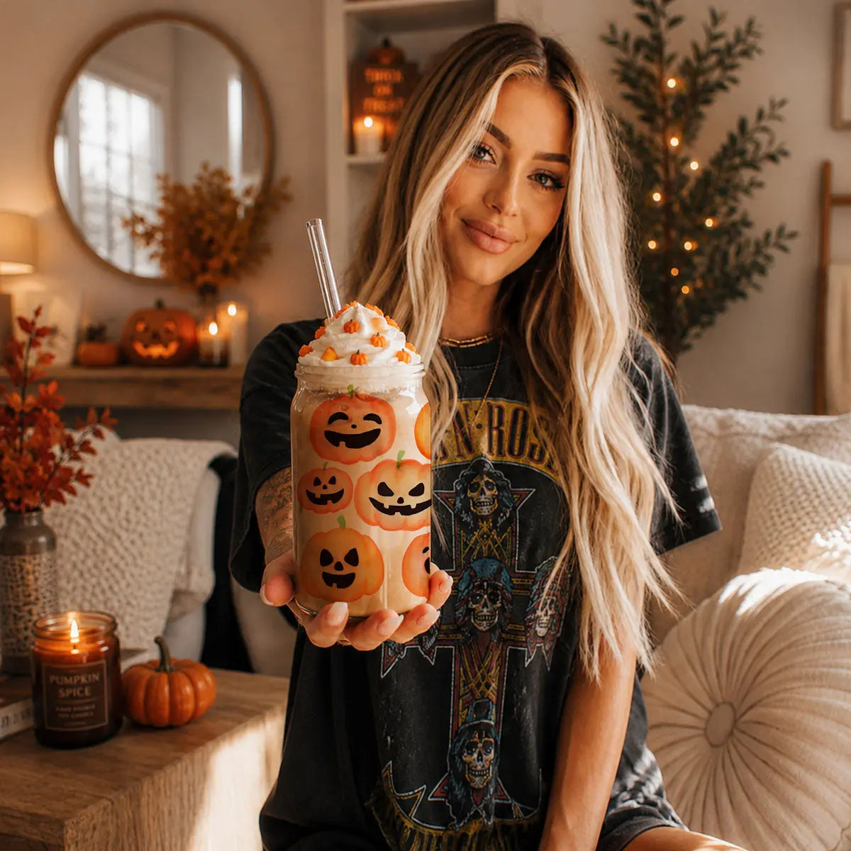Woman holding a Halloween-themed drink in a decorated living room.
