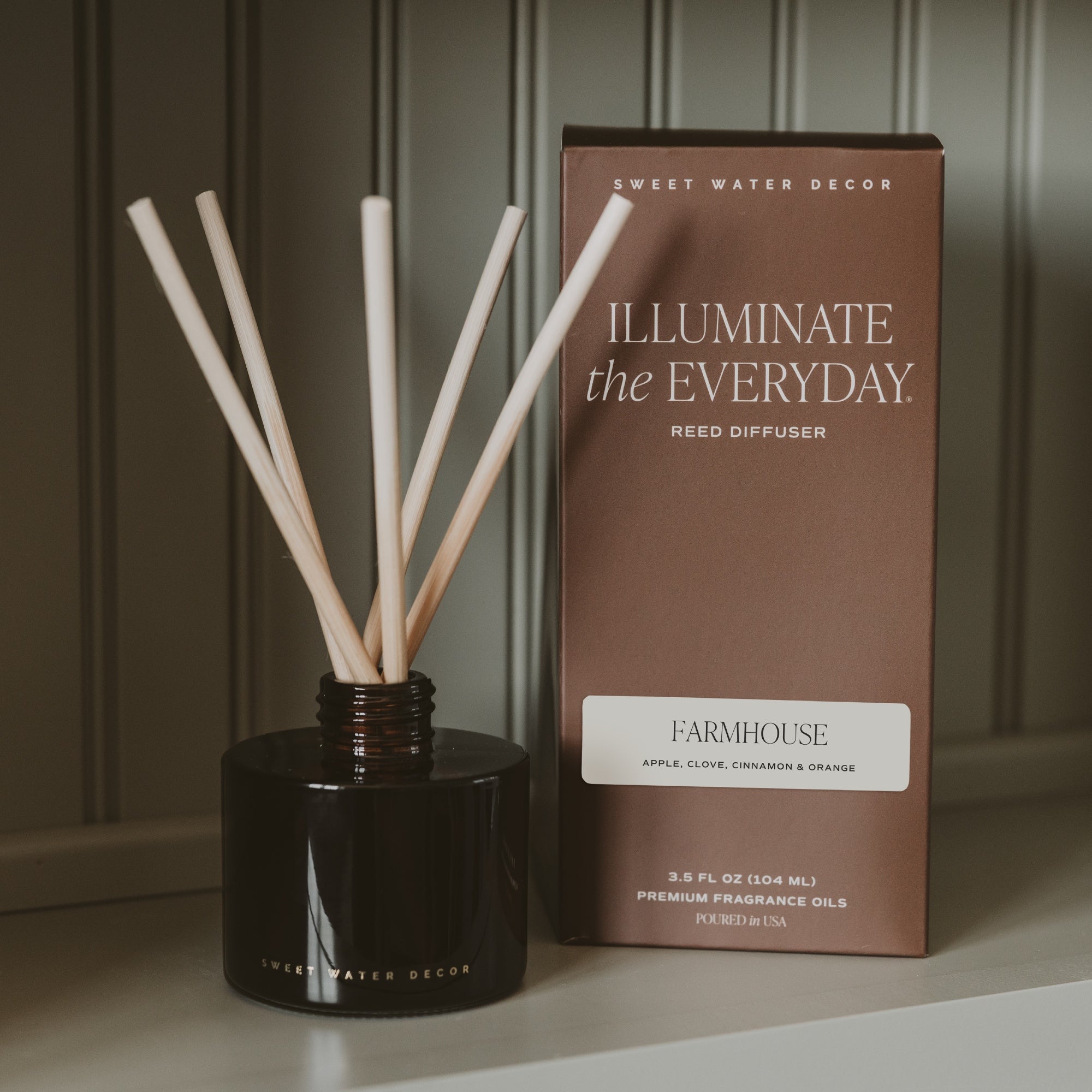 Farmhouse amber tinted glass reed diffuser with natural rattan reeds and warm pumpkin, apple, cinnamon, caramel, and vanilla fall fragrance.