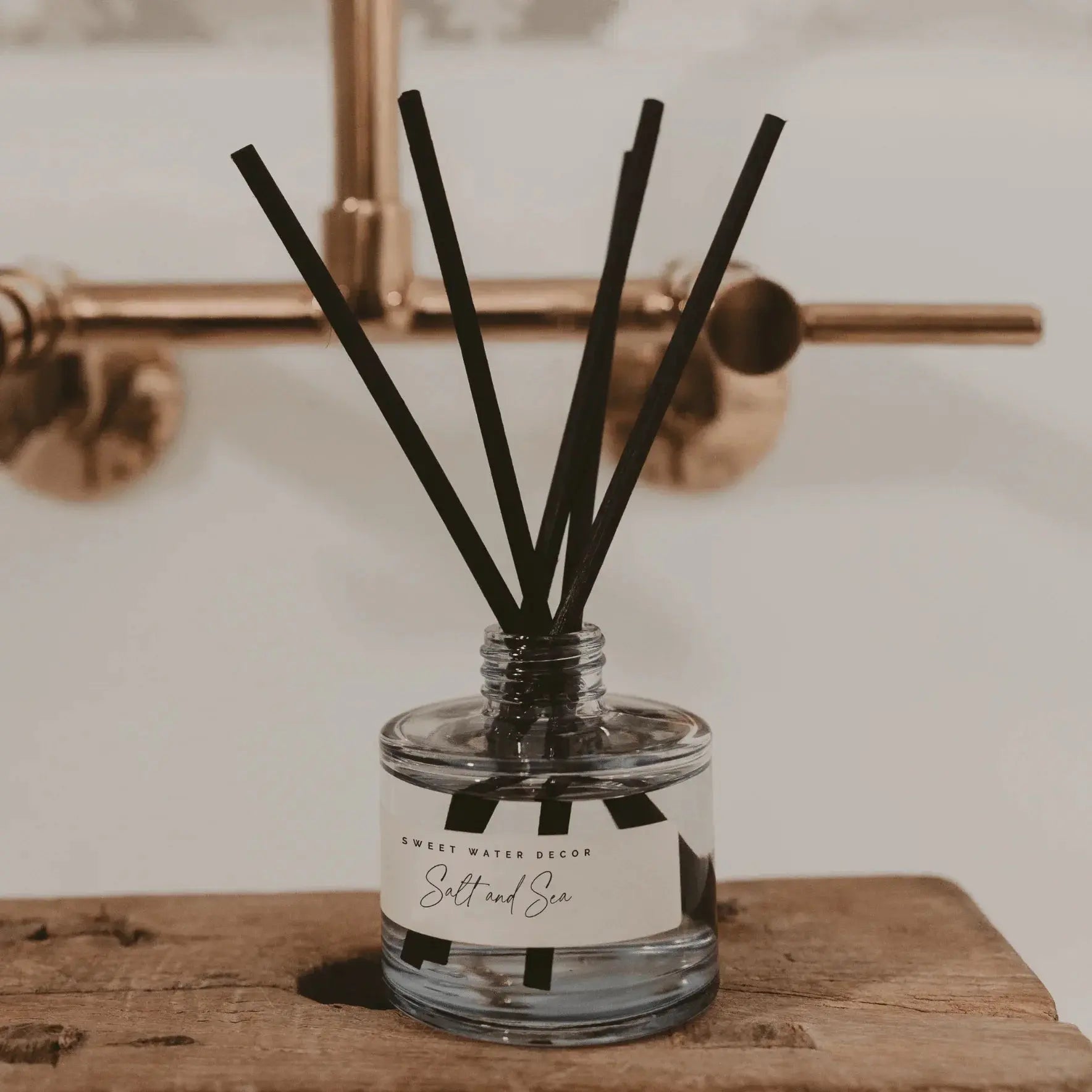 Salt and Sea reed diffuser with black sticks, farmhouse bathroom decor on rustic wood