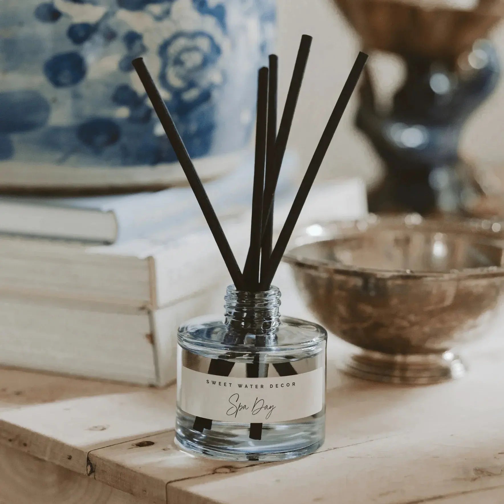 Spa Day reed diffuser with black sticks, cozy farmhouse decor on wooden shelf