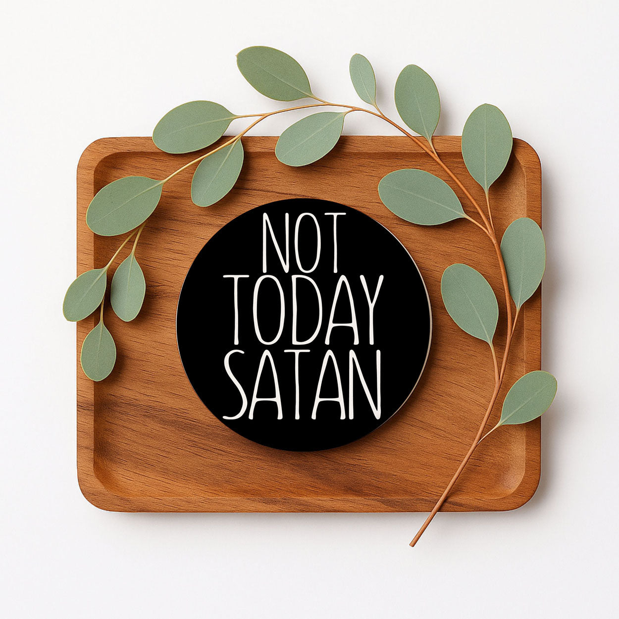 Wooden tray with a 'Not Today Satan' coaster and green leaves on a white background