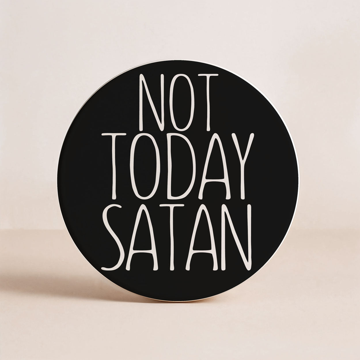 Round black sticker with 'Not Today Satan' text on a beige background