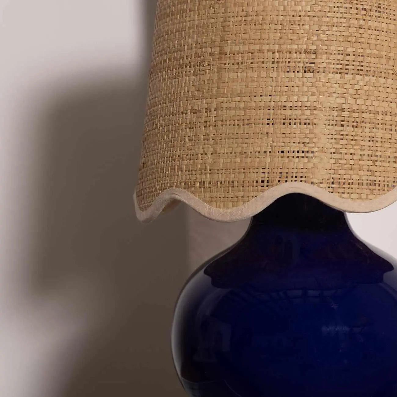 Cozy farmhouse table lamp with woven rattan shade and navy blue ceramic base, perfect for cottage style decor