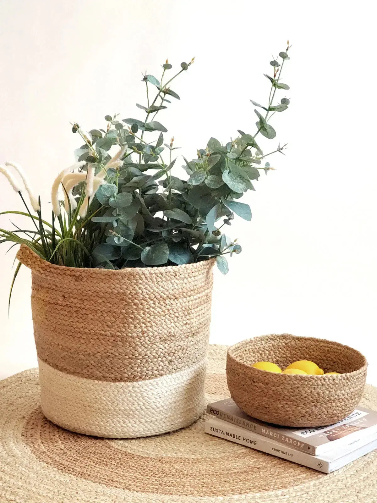 Woven seagrass basket with eucalyptus, matching bowl with lemons, farmhouse decor on jute mat