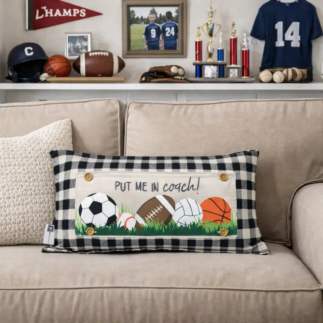 Decorative pillow with sports balls and text on a beige couch