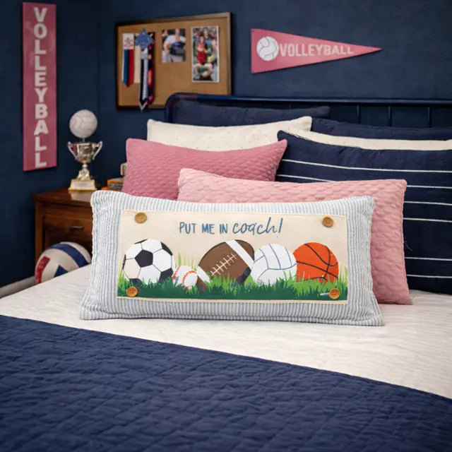 Bedroom with sports-themed decor, including a pillow with sports balls and 'Put Me in Coach!' text.