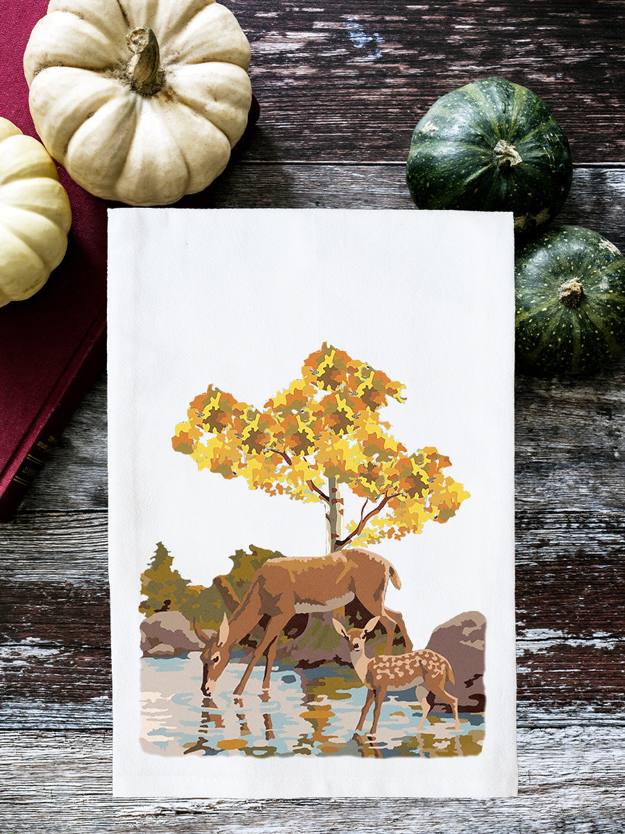 Card with deer and autumn scene on a wooden surface with pumpkins