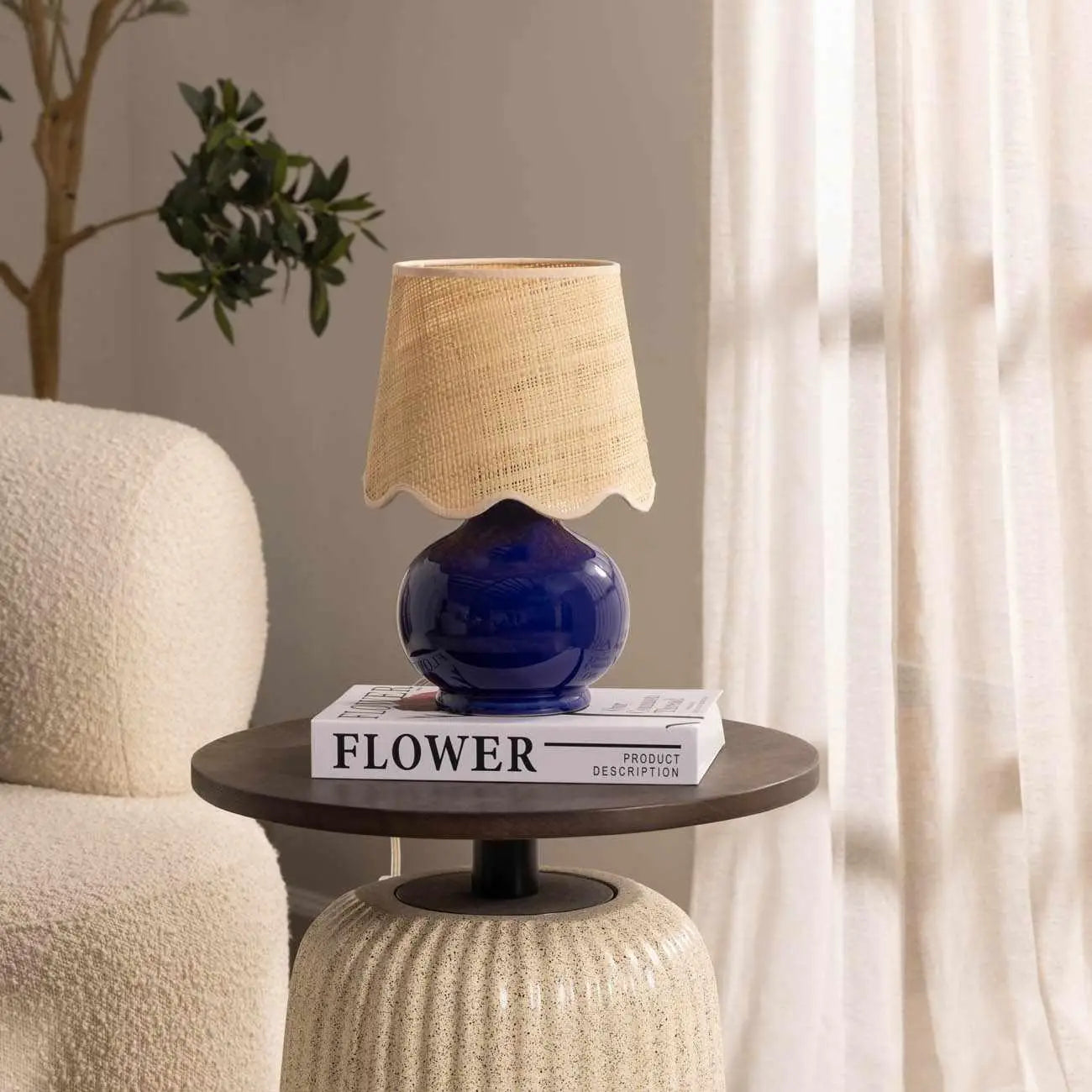 Cozy farmhouse table lamp with navy ceramic base and woven shade, styled on side table with book