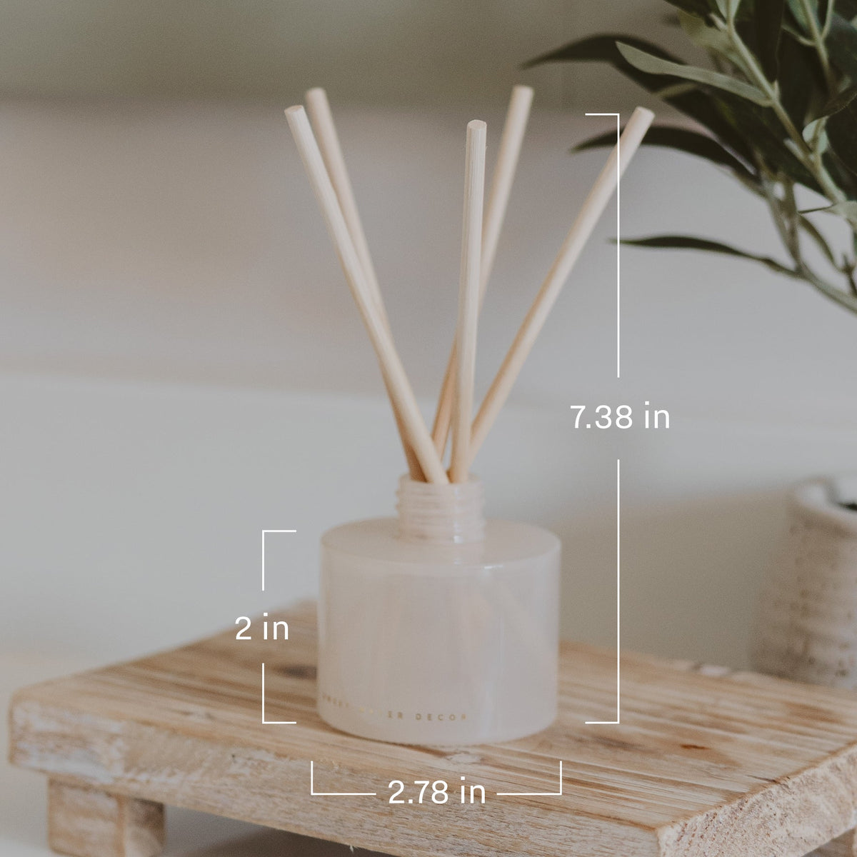 Reed diffuser with measurement labels on a wooden surface
