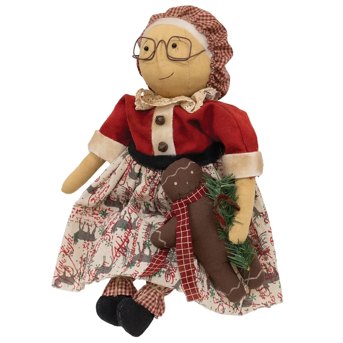 A rustic Christmas hanging doll with a beige face and hands, wearing a red top, patterned skirt, and a brown plaid bonnet, holding a gingerbread man figure and green pine sprigs against a white background.