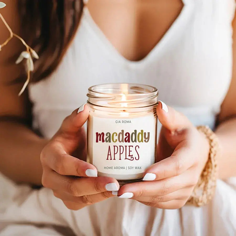 Person holding a 'comfy & cozy' candle jar