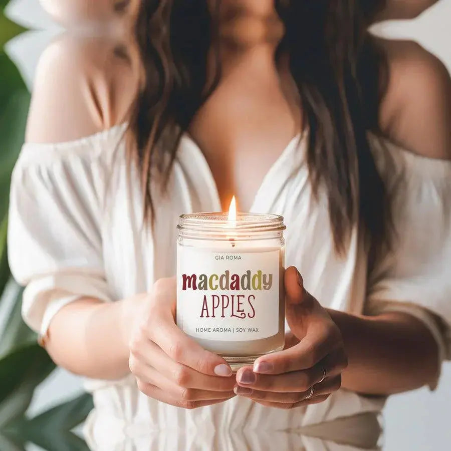 Person holding a 'Comfy & Cozy' candle with a blurred background