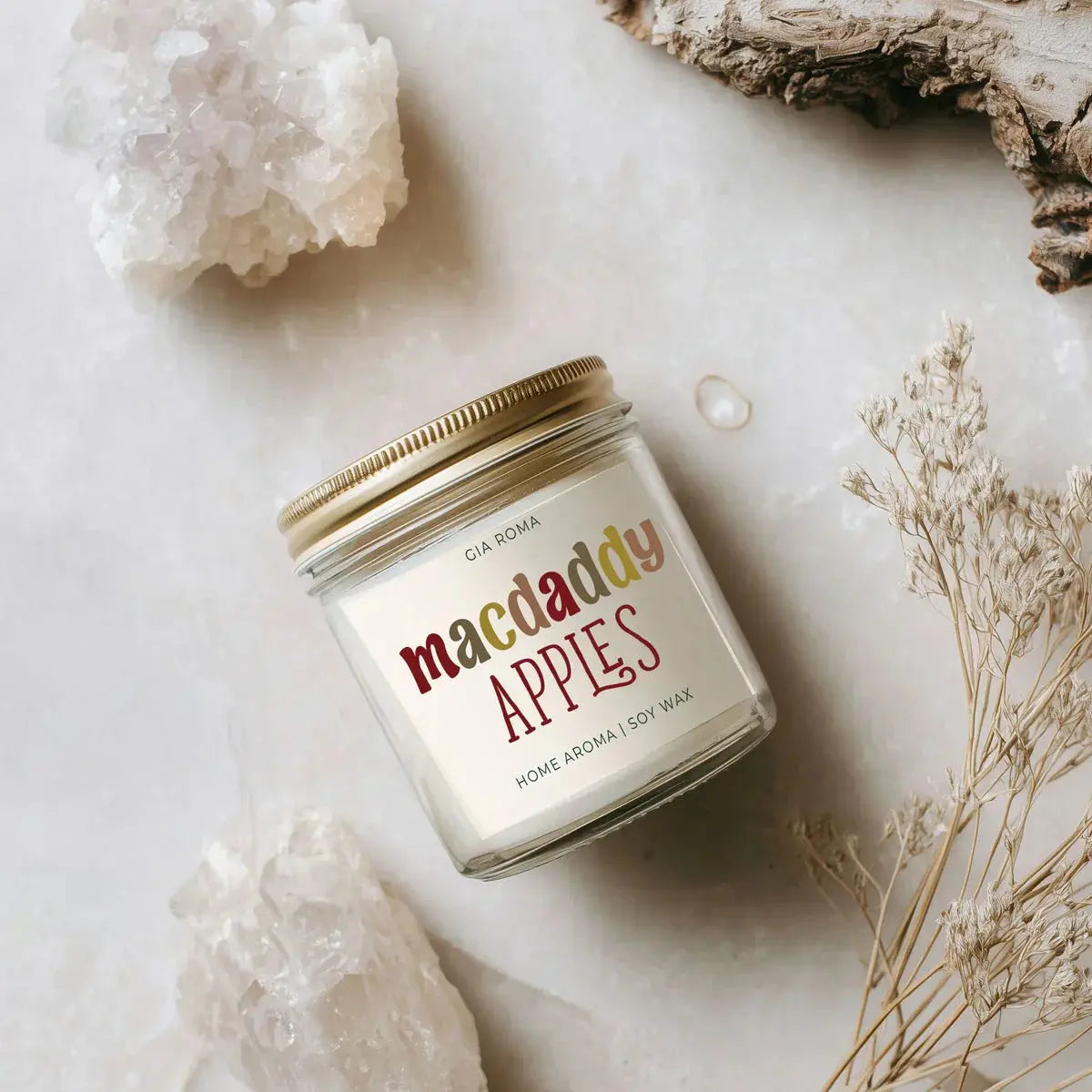 Candle jar labeled 'comfy & cozy' on a marble surface with crystals and dried plants.