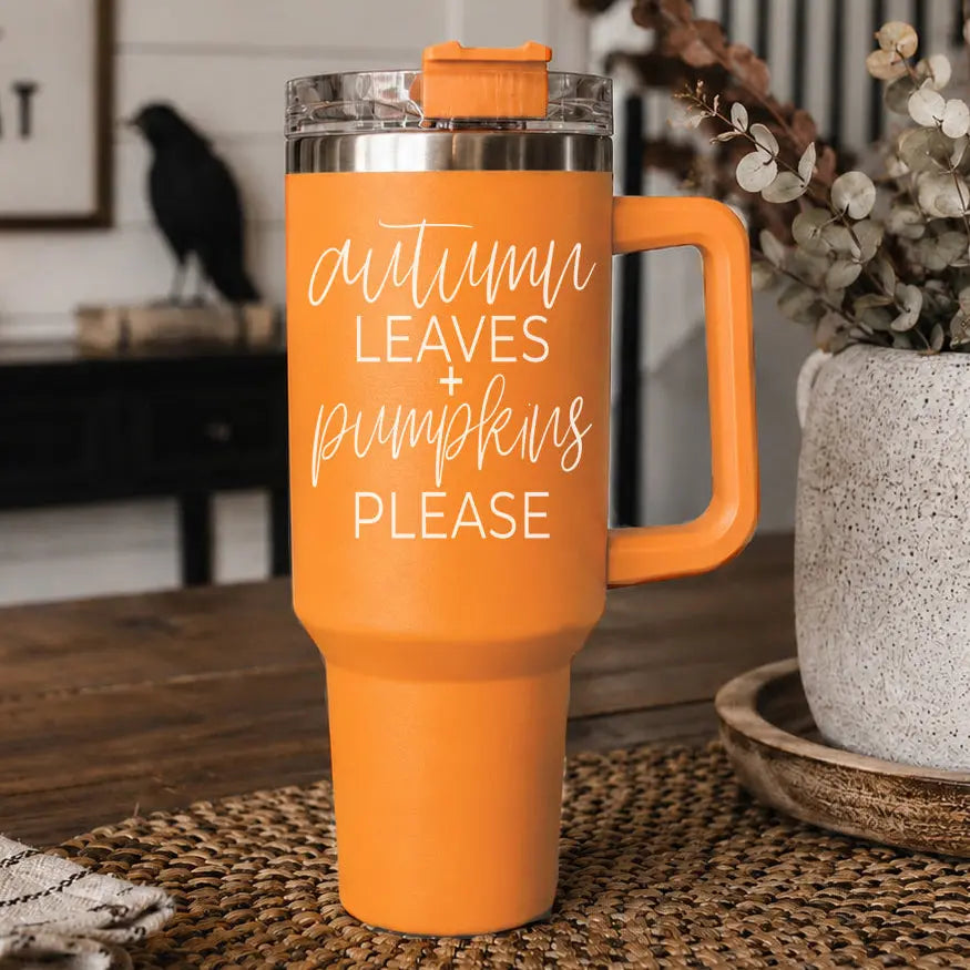  Auumn Leaves + Pumpkins Please Orange Tumblersitting on a brown jute table runner with a white planter filled with a arrangement