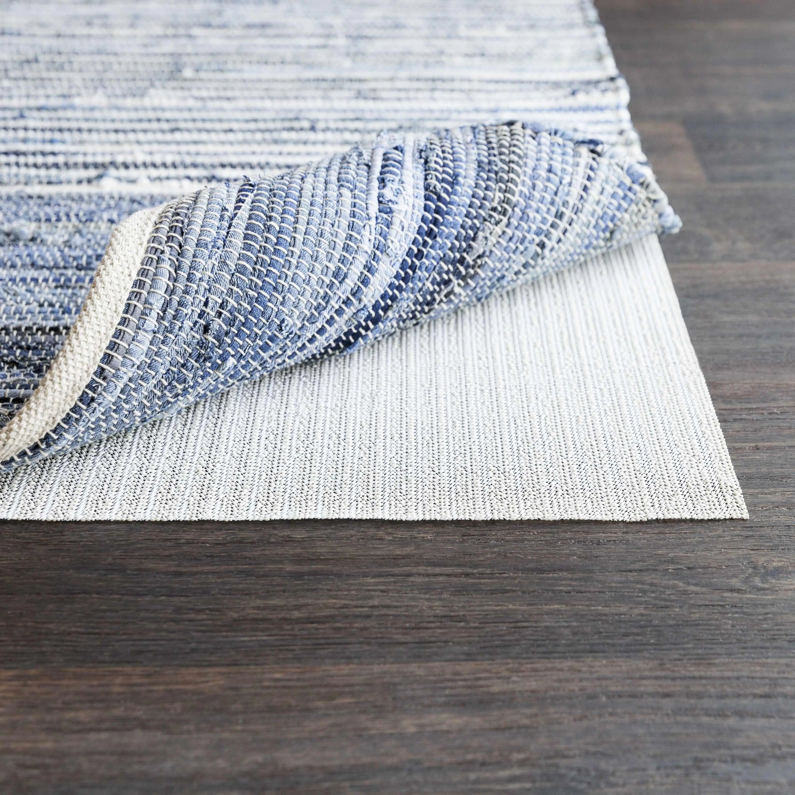 Blue and white woven farmhouse rug on dark wood floor, cozy cottage style decor