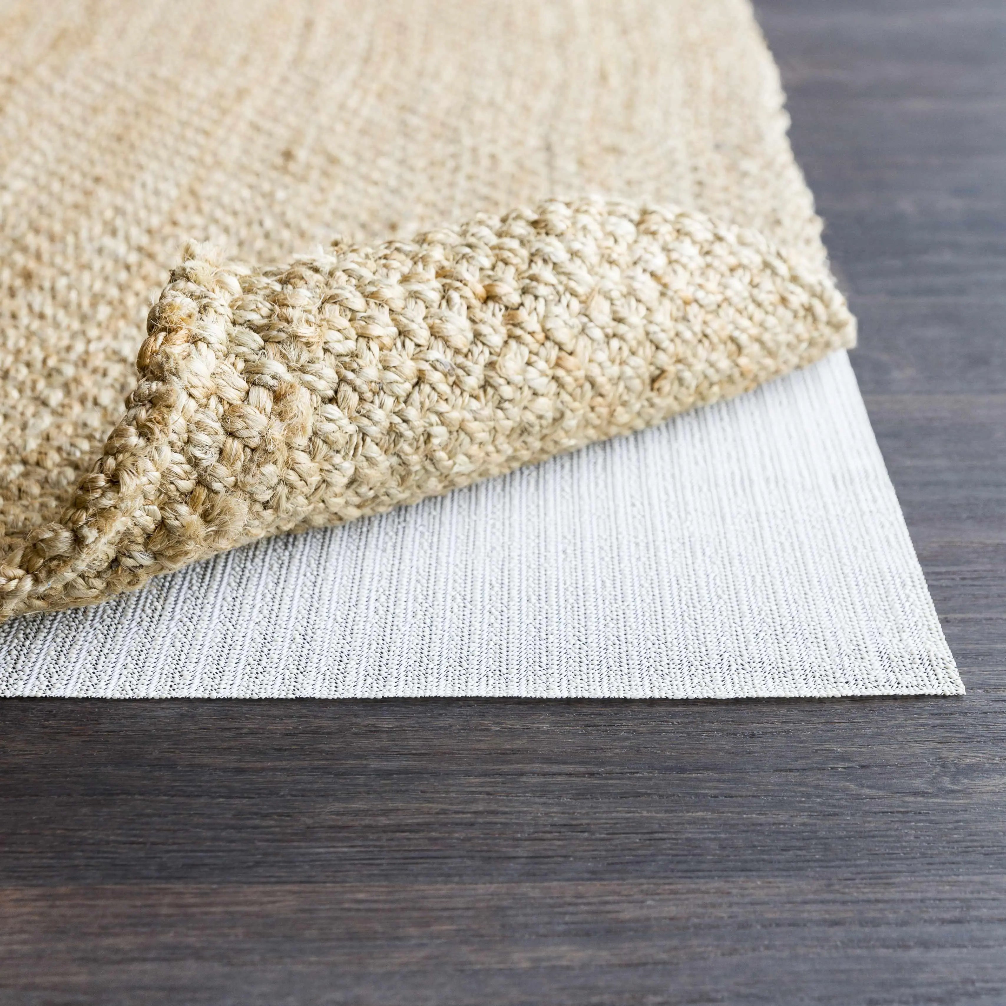 Natural woven jute rug with textured edge on dark wood floor, farmhouse style home decor