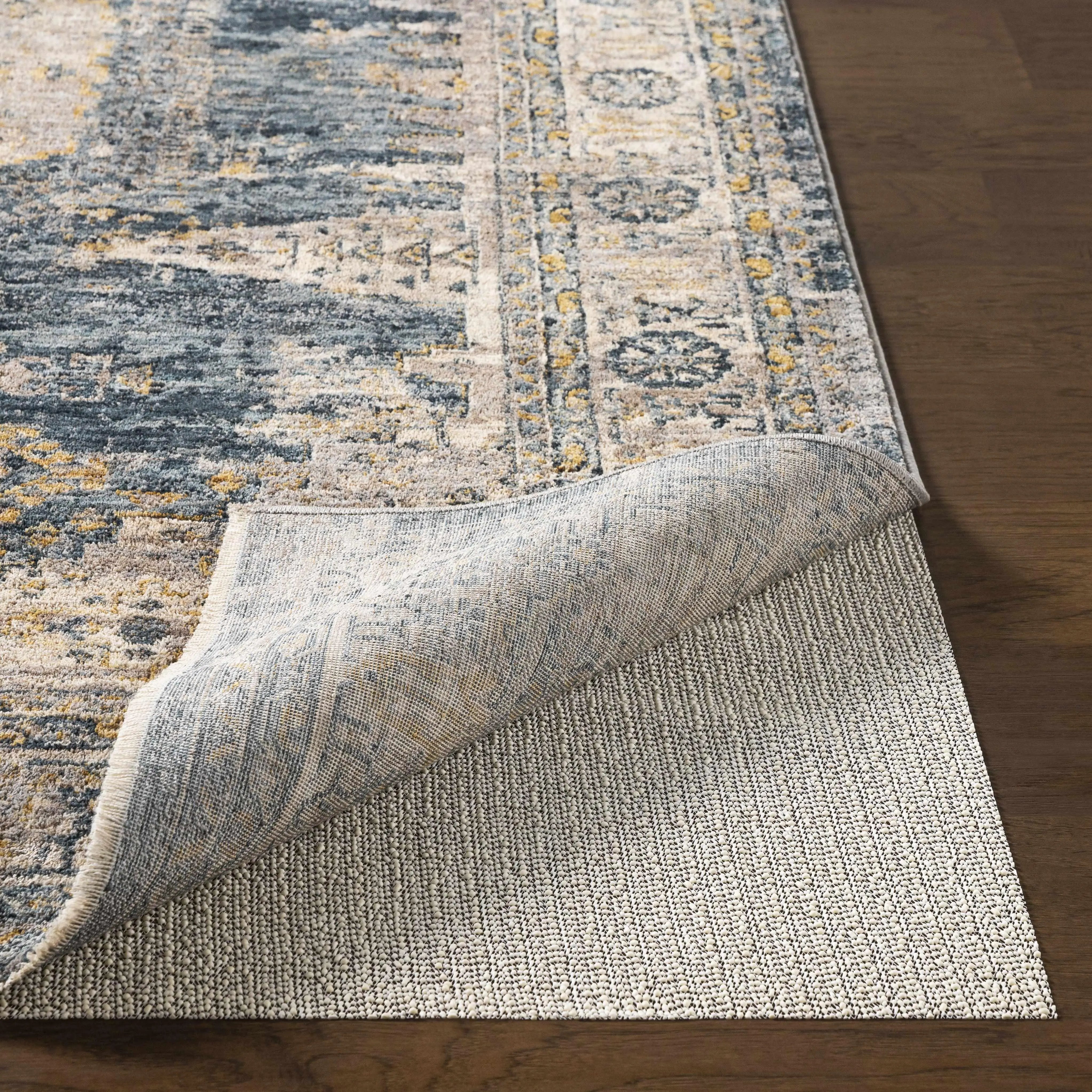 Cozy farmhouse-style area rug with blue, beige, and yellow vintage pattern on hardwood floor