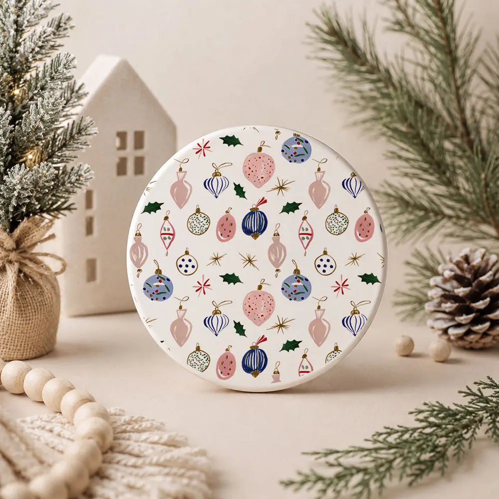 Round decorative item with Christmas ornament pattern on a neutral background with festive elements.