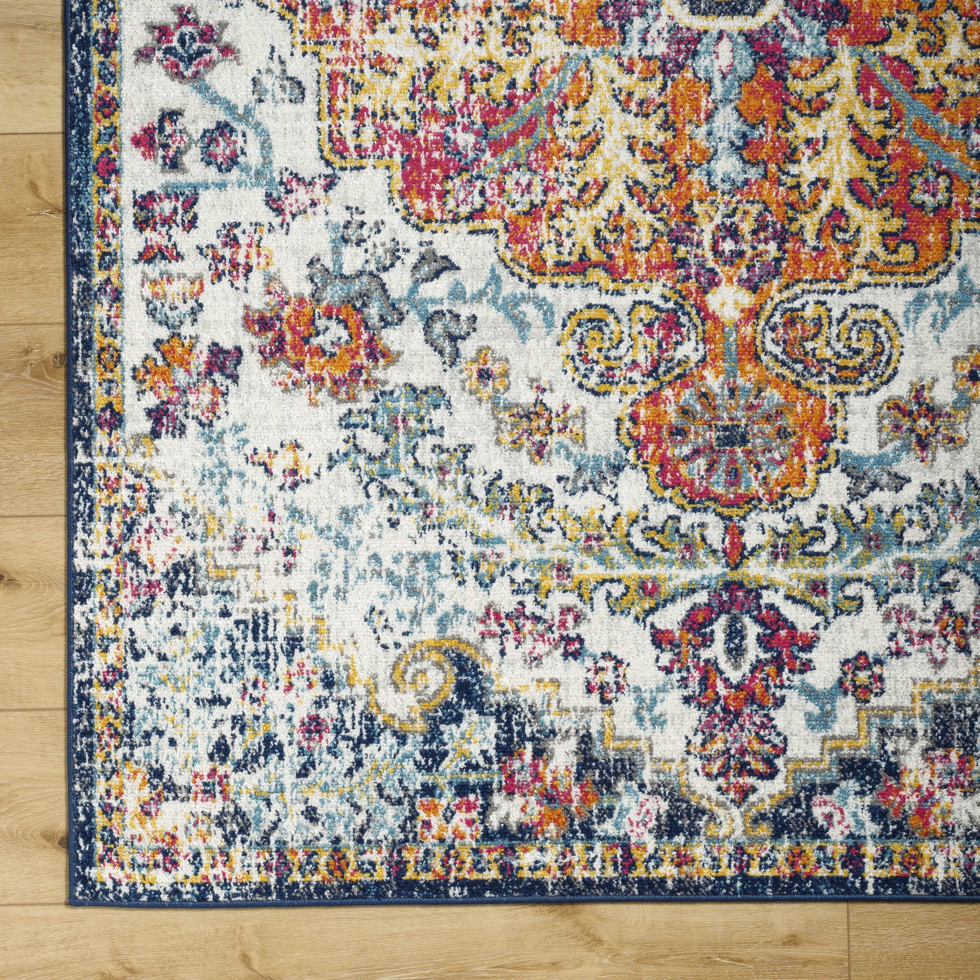 Colorful vintage-style area rug with floral patterns on hardwood floor, cozy farmhouse decor