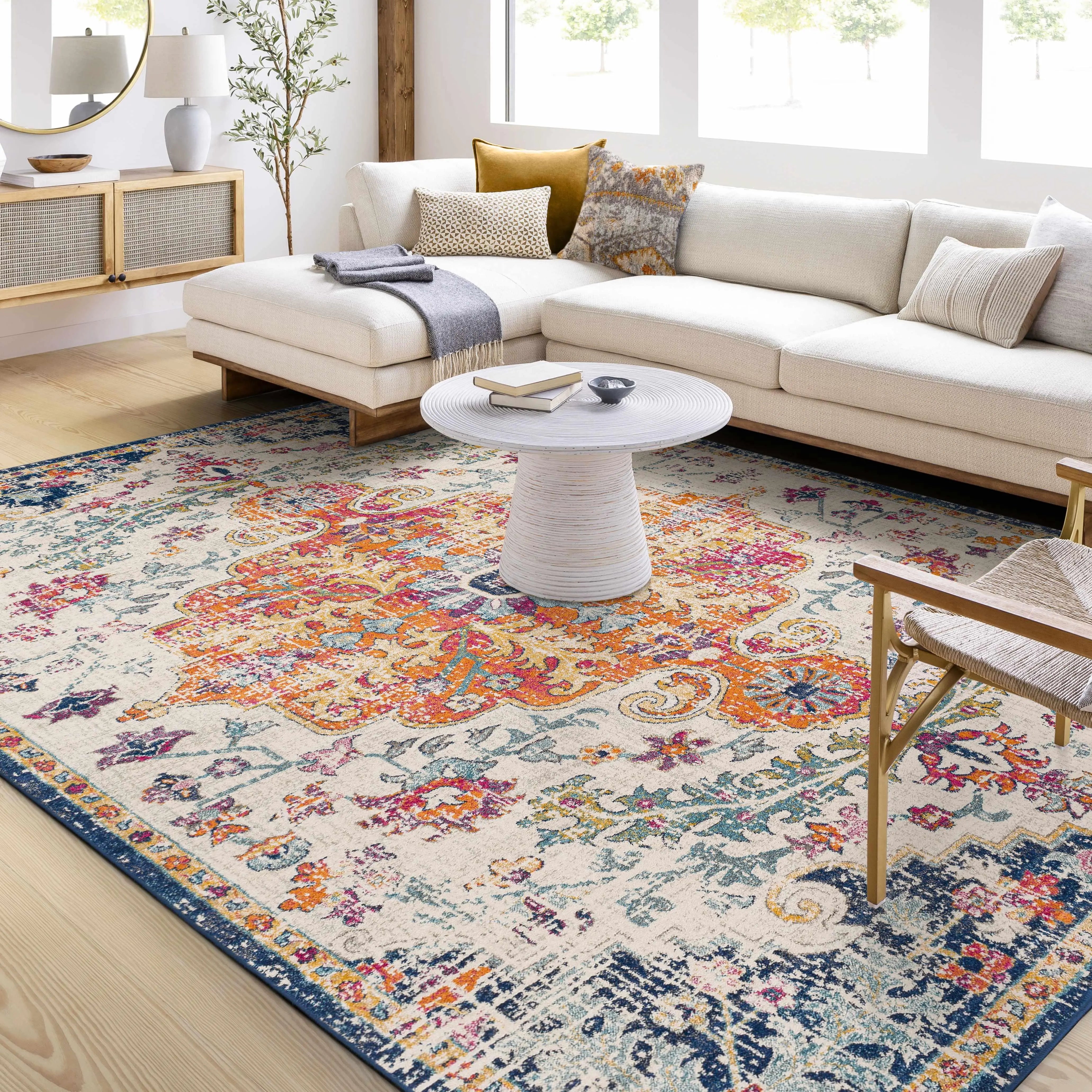 Cozy farmhouse living room with floral area rug, white sectional sofa, and rustic decor accents