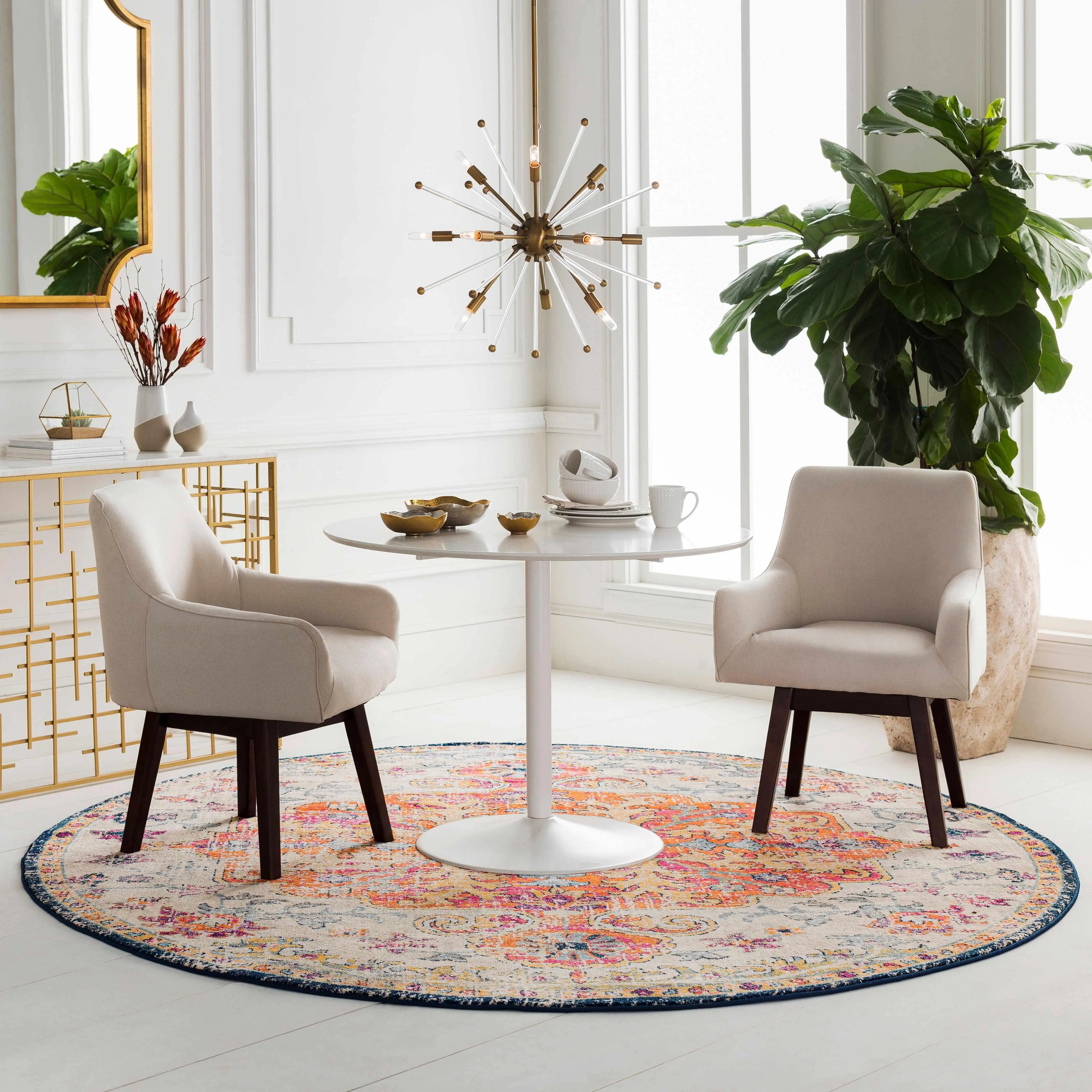 Cozy farmhouse dining setup with round table, beige chairs, and vibrant rug near large window