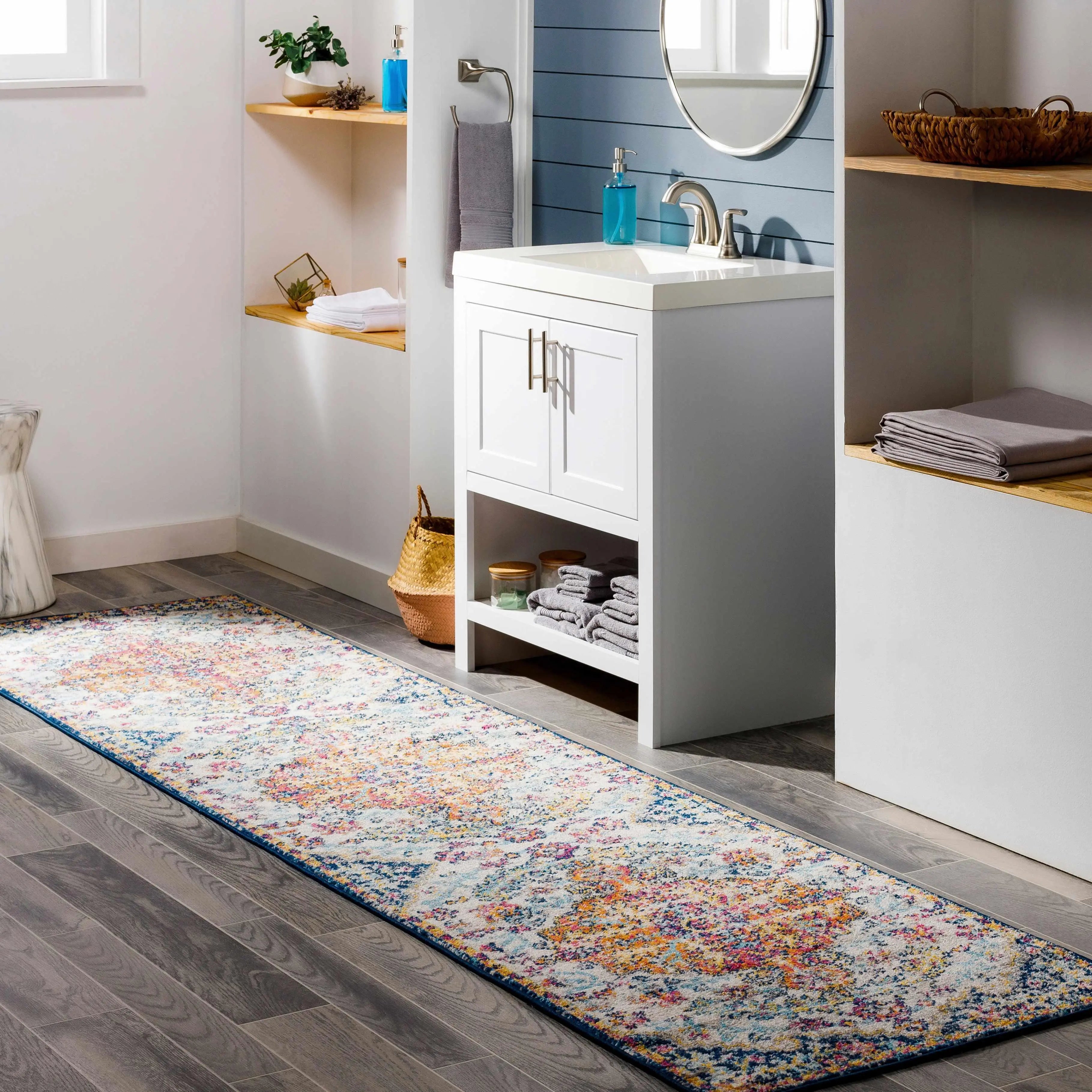 Colorful floral bathroom runner rug with blue border on gray wood floor, cozy farmhouse decor