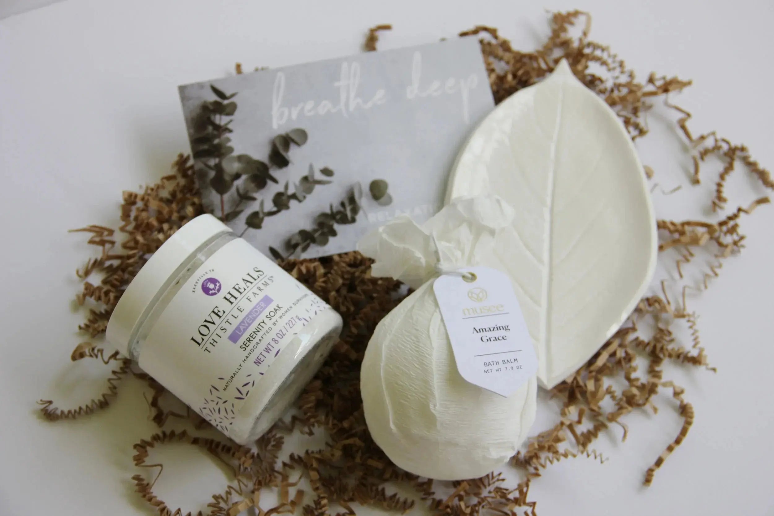 Lavender serenity soak, Amazing Grace bath balm, and leaf dish on crinkle paper for cozy home spa relaxation
