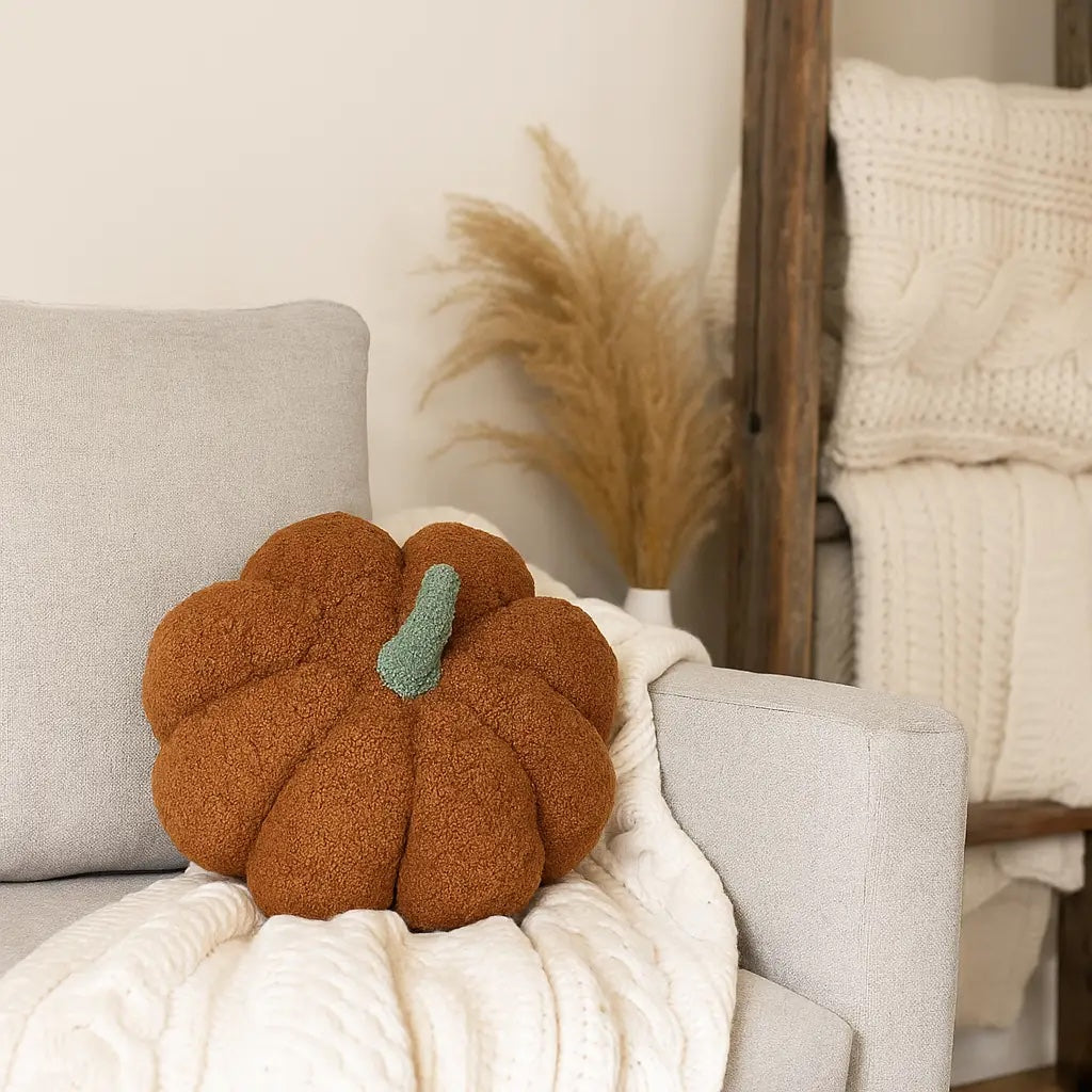 Decorative brown pumpkin pillow on a sofa with a neutral background