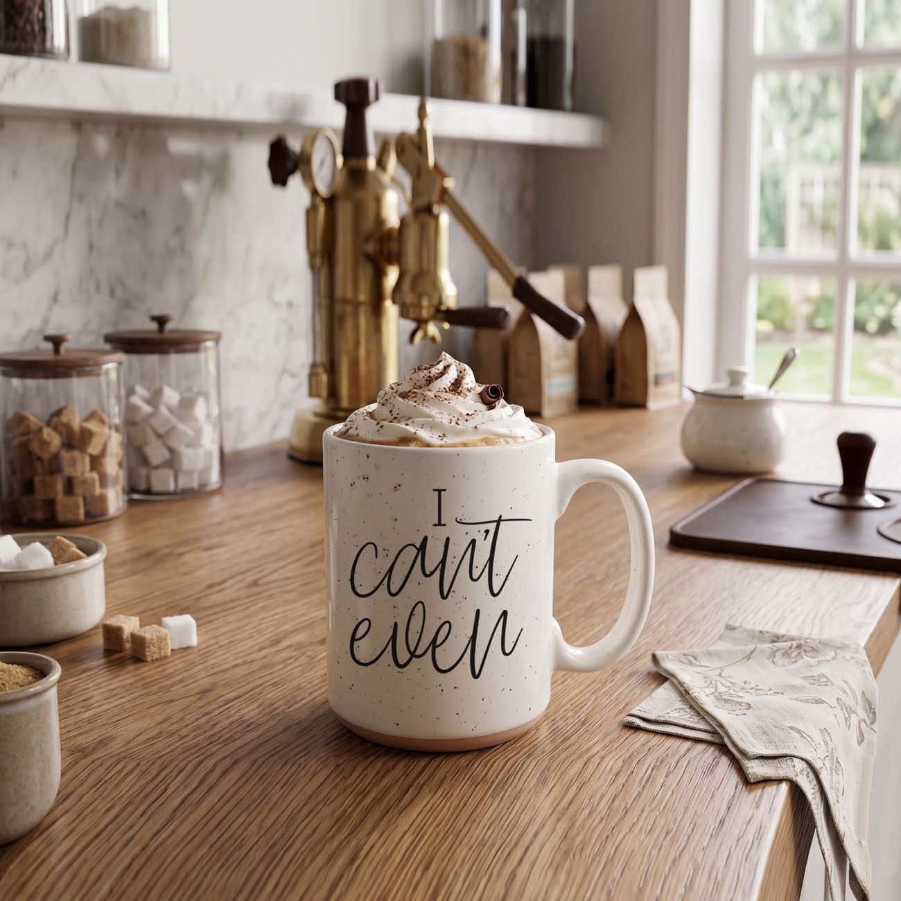 Mug with 'I can't even' text on a kitchen counter with coffee and cream.