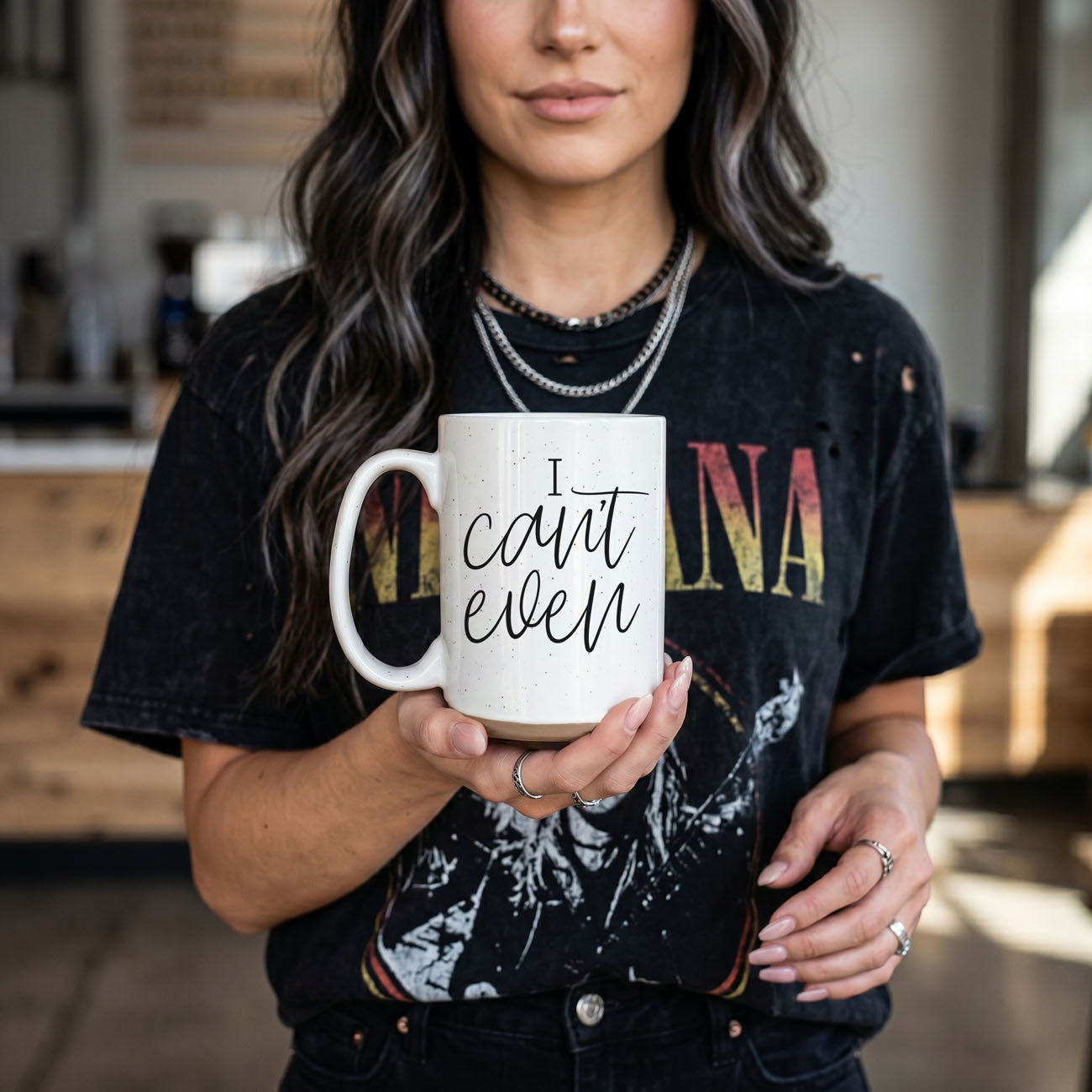 Person holding a mug with text in a casual setting
