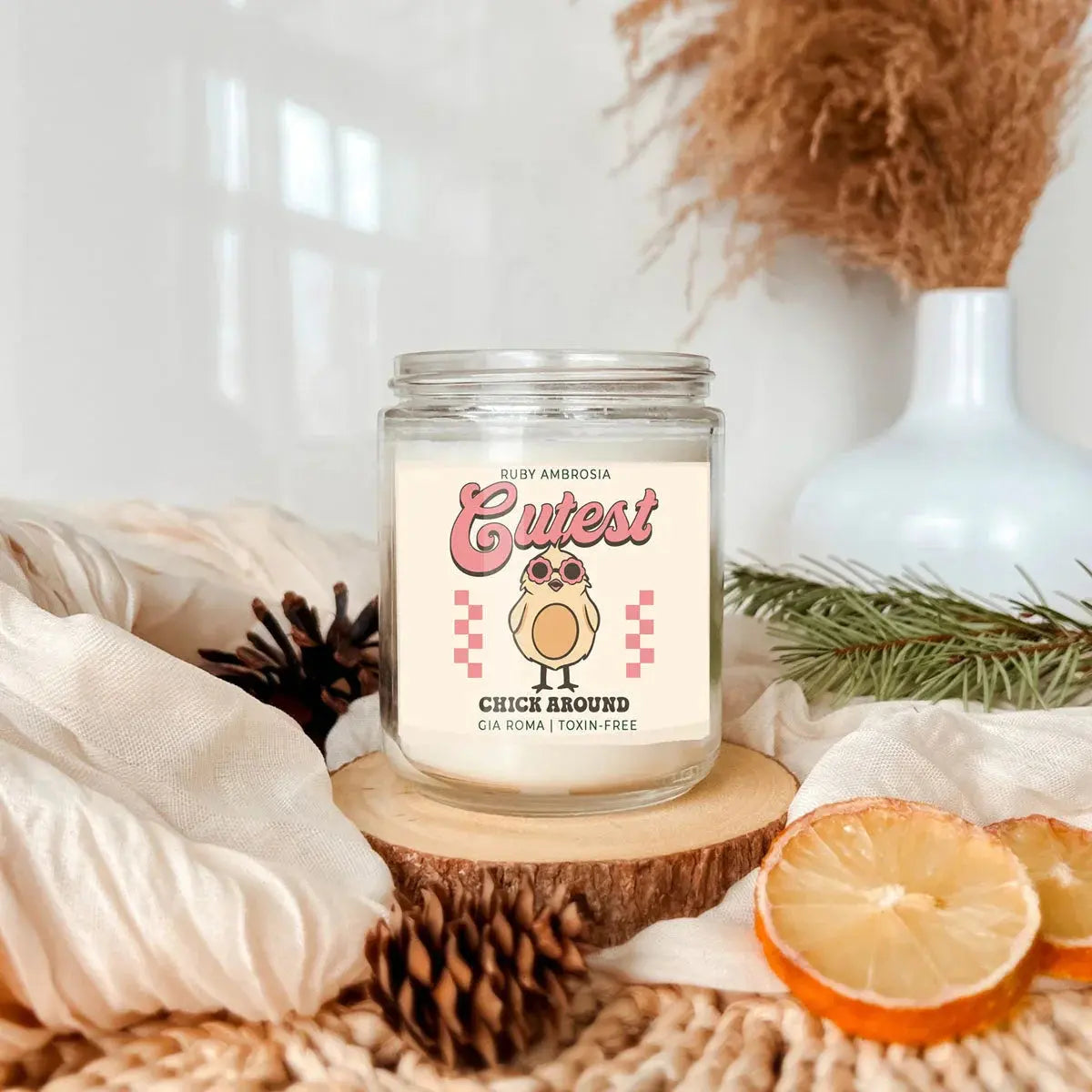 Candle with a cute owl design on a wooden coaster with decorative elements.