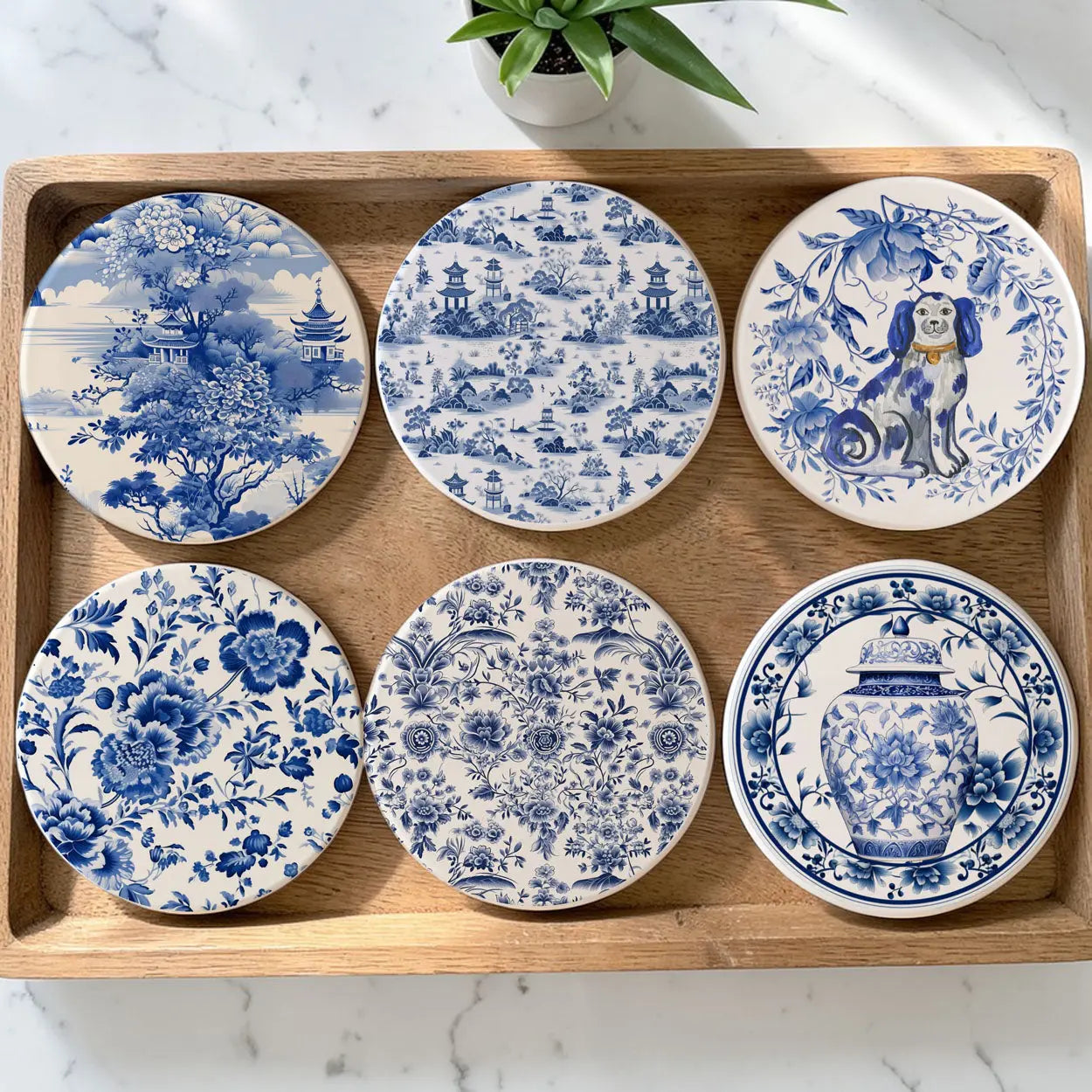 Set of six blue and white ceramic coasters with various designs on a wooden tray.