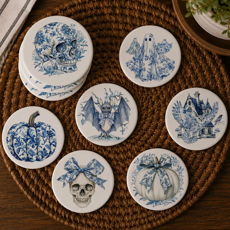 Set of blue and white ceramic coasters with Halloween-themed designs on a woven mat.
