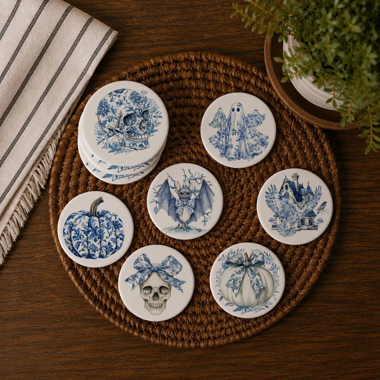 Set of blue and white ceramic coasters on a woven mat with a plant and towel in the background.